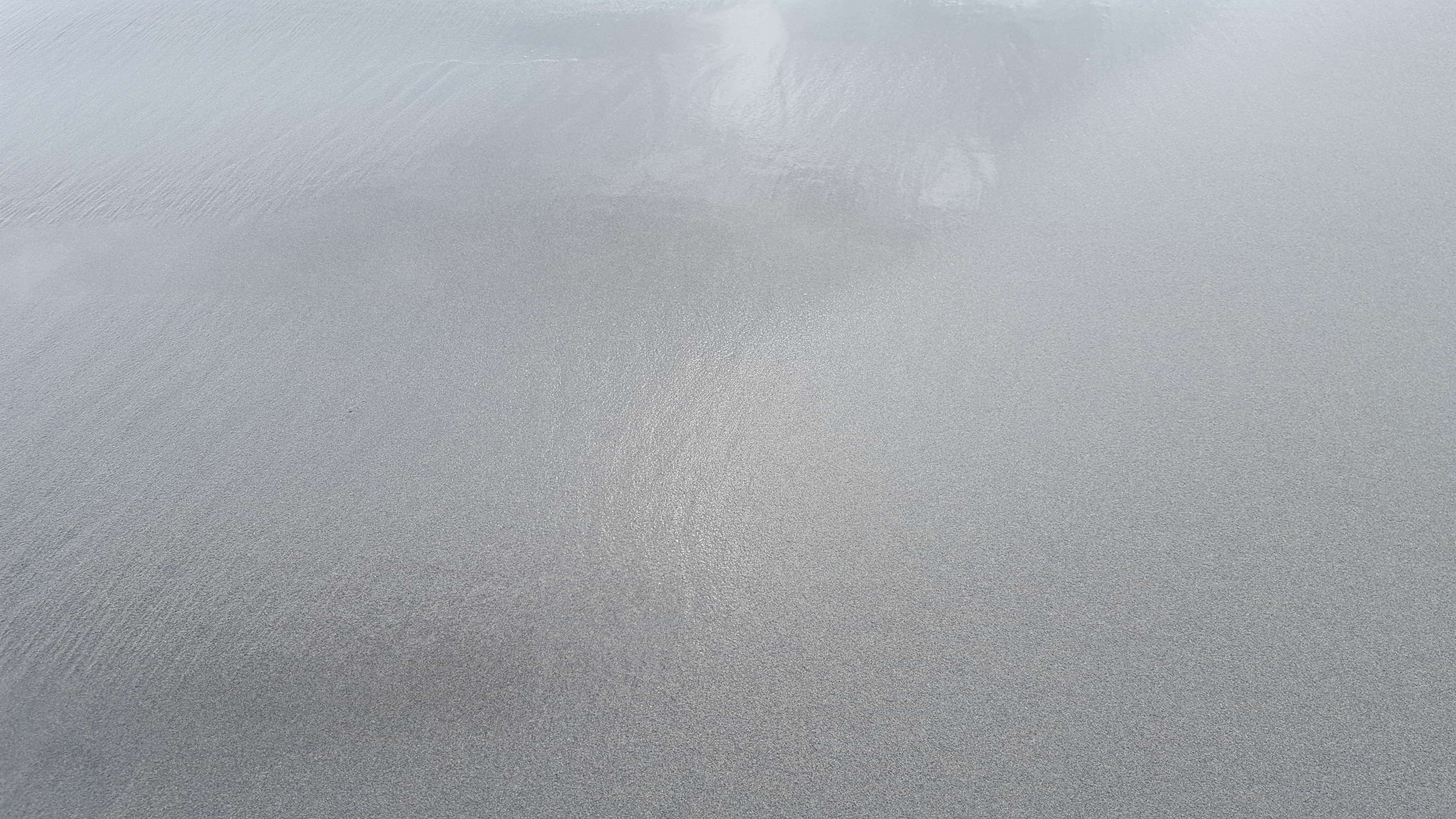 Wet sand with reflections on the seashore HD Wallpaper