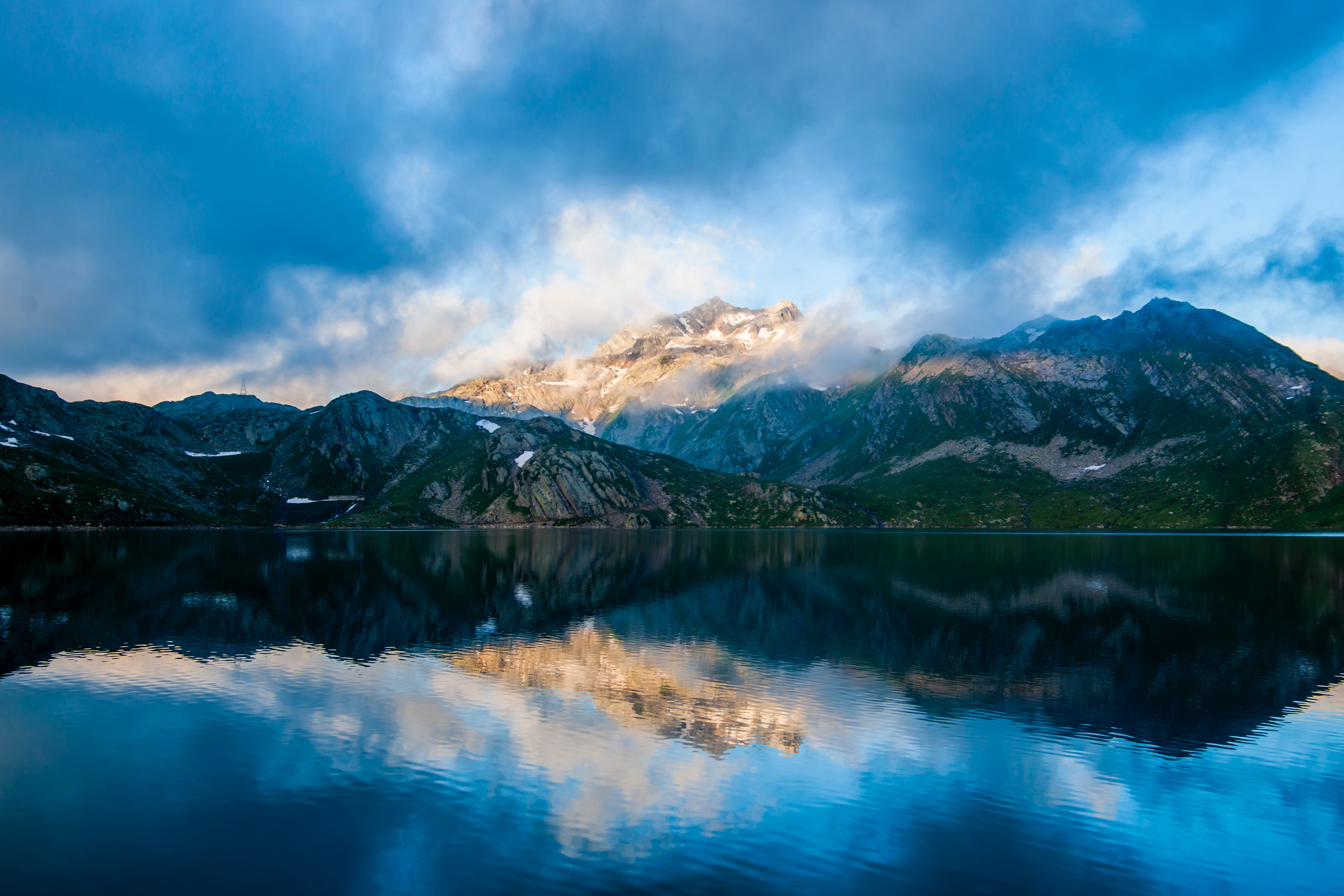 Mountain range reflected in a tranquil lake at dawn HD Wallpaper