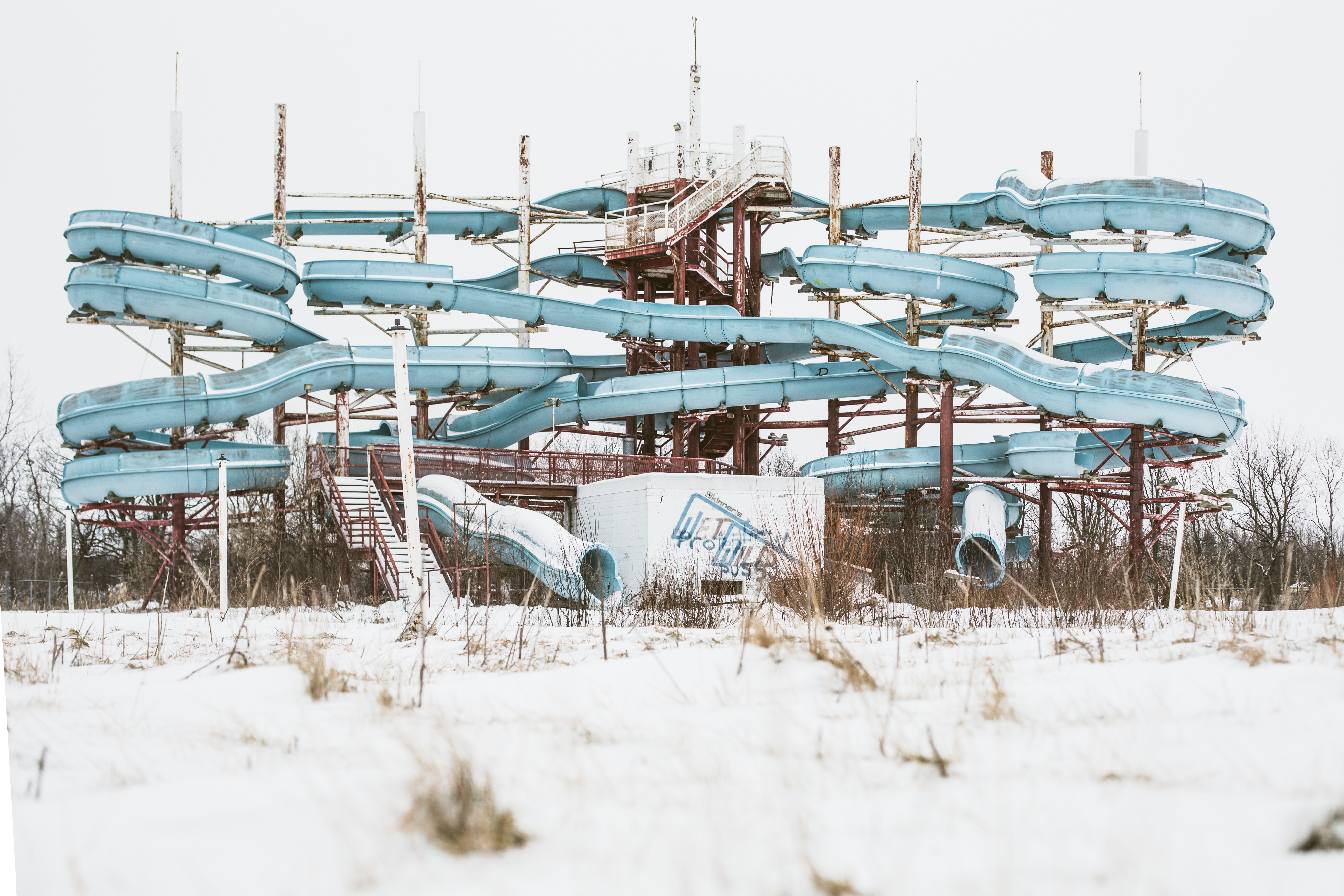 Abandoned water slides in a snowy field HD Wallpaper