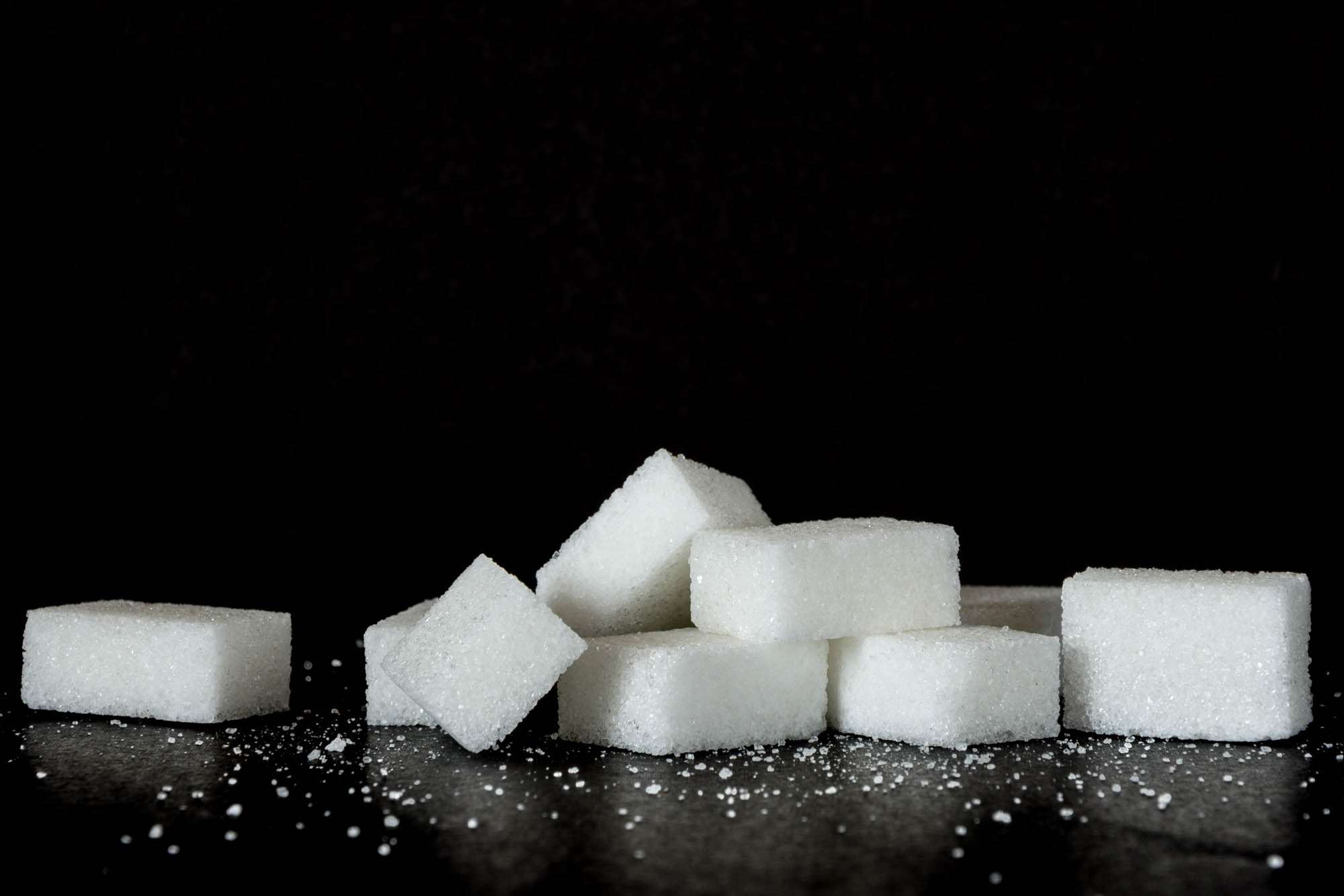 Pile of sugar cubes on a black background HD Wallpaper