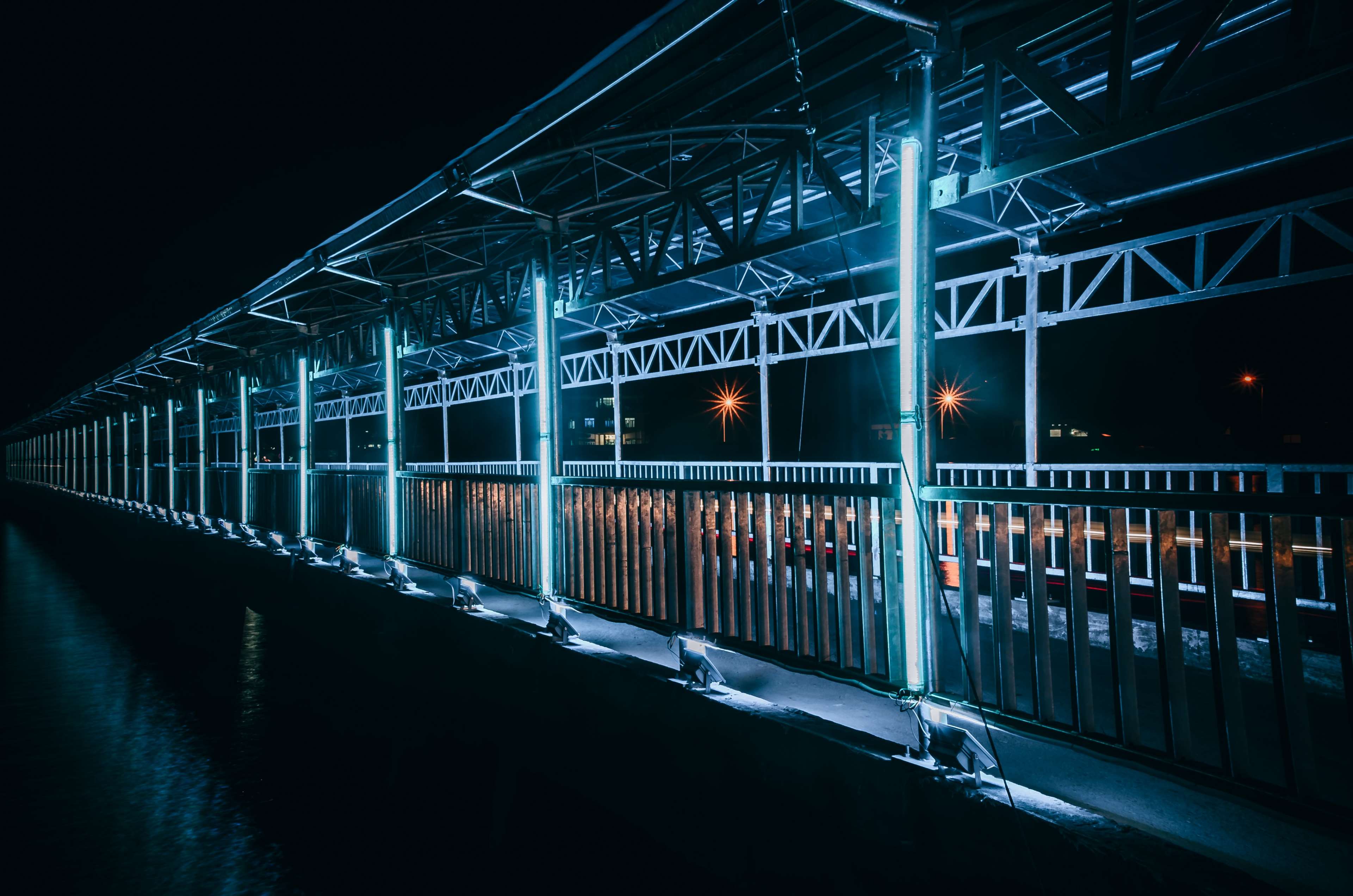 Illuminated modern bridge at night with reflections HD Wallpaper
