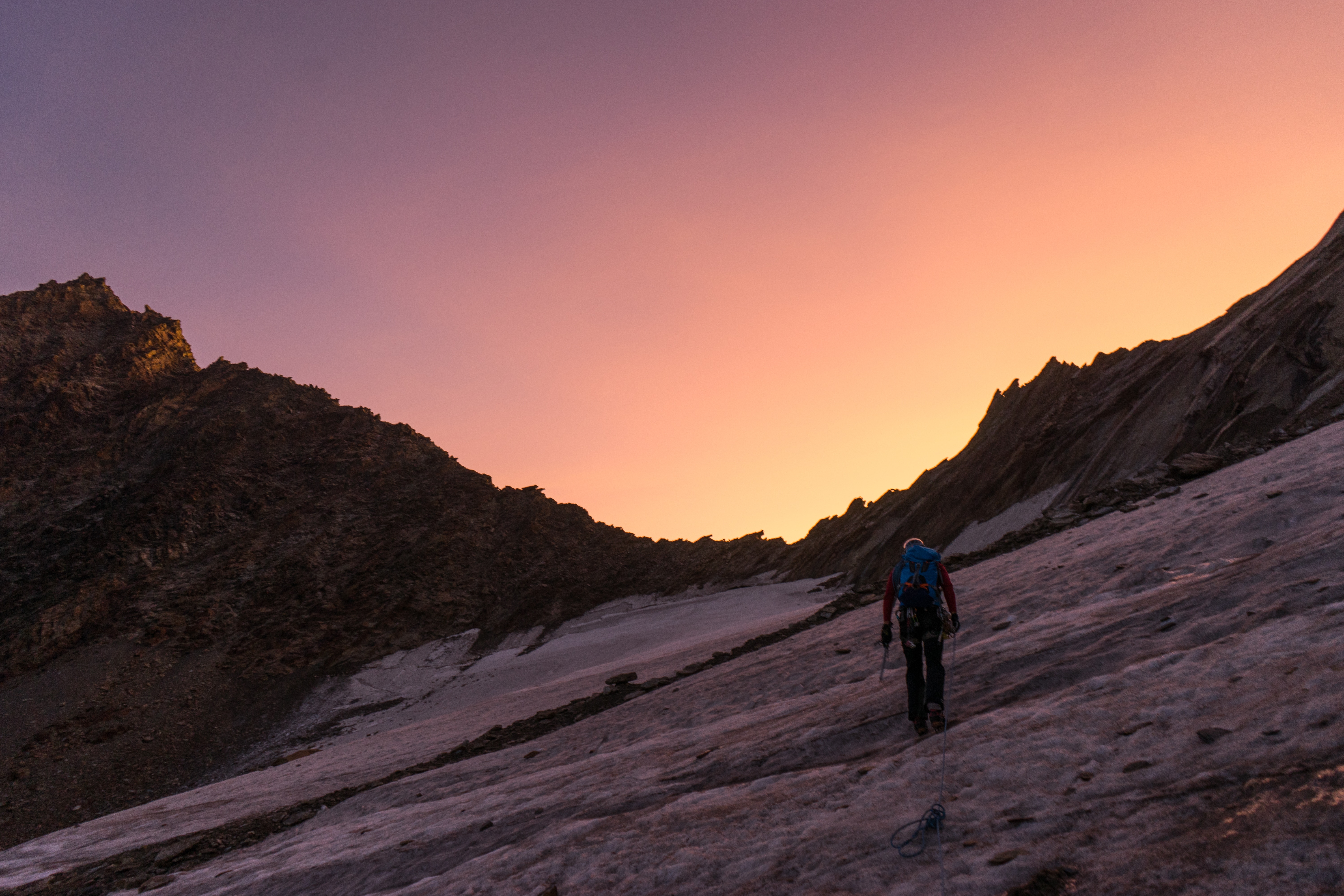 Alpinist hiking on a glacier at sunrise in Switzerland HD Wallpaper