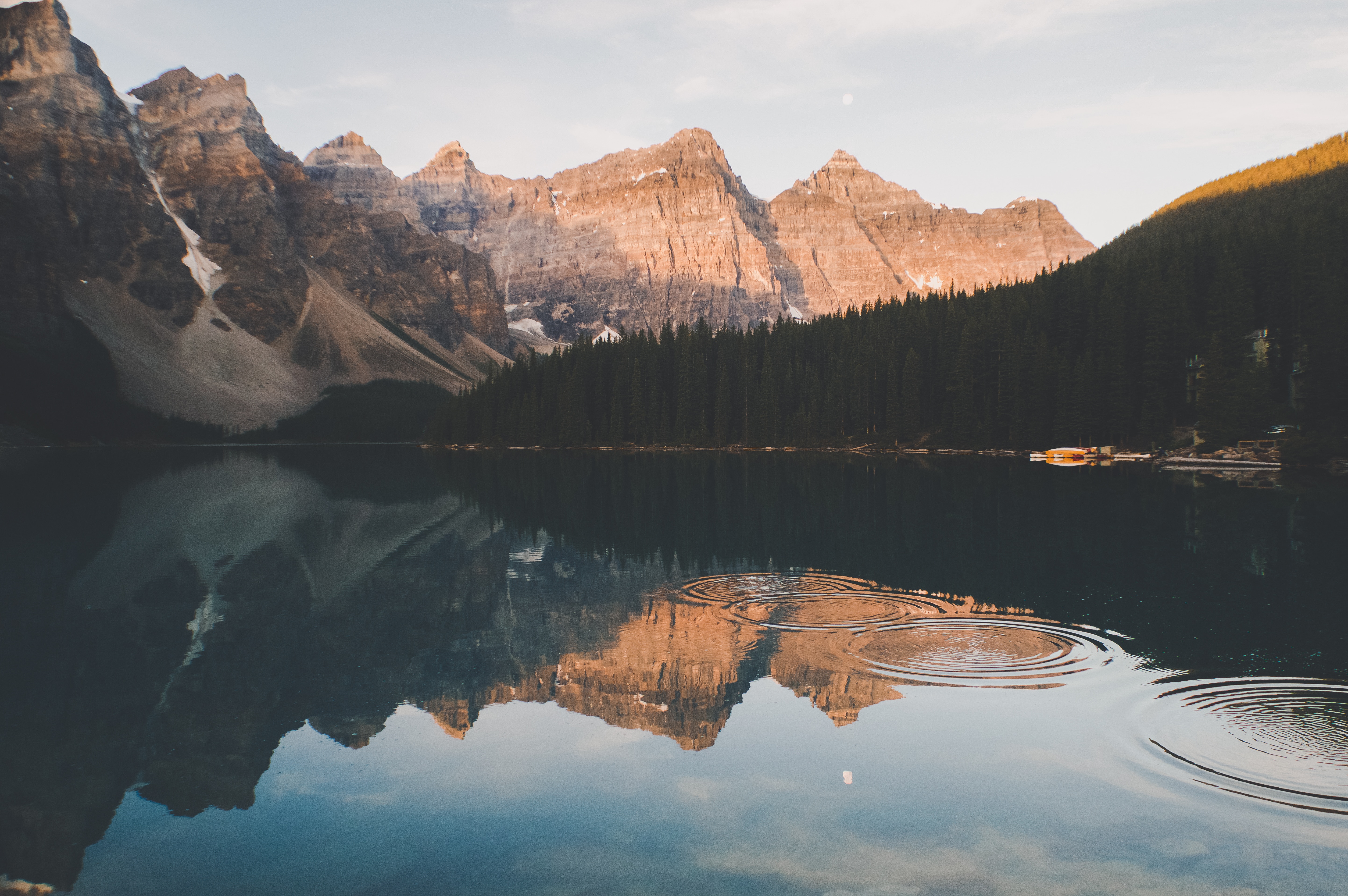 Mountain range reflected in a calm lake with ripples HD Wallpaper
