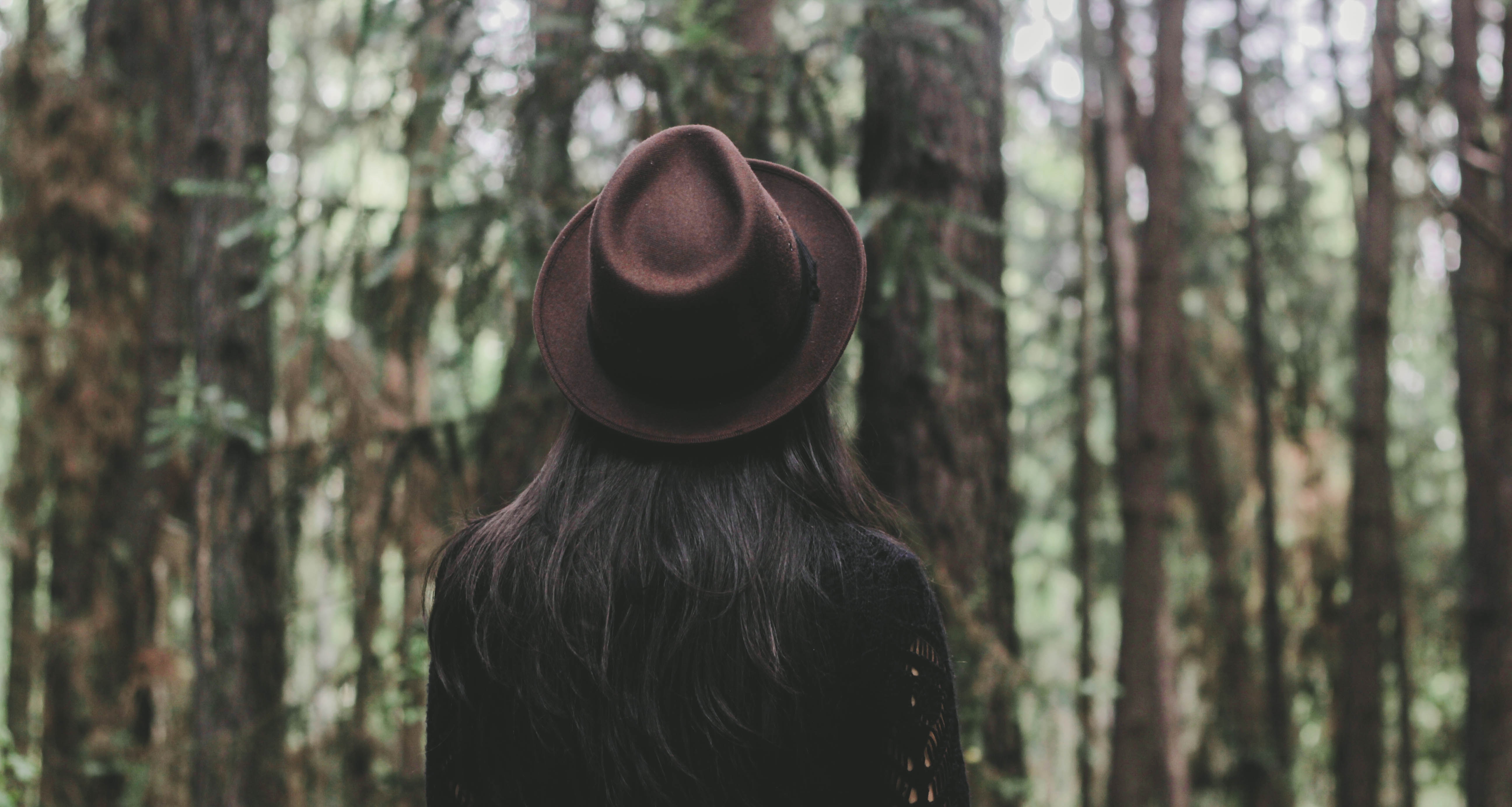 Woman wearing a brown hat in a forest HD Wallpaper