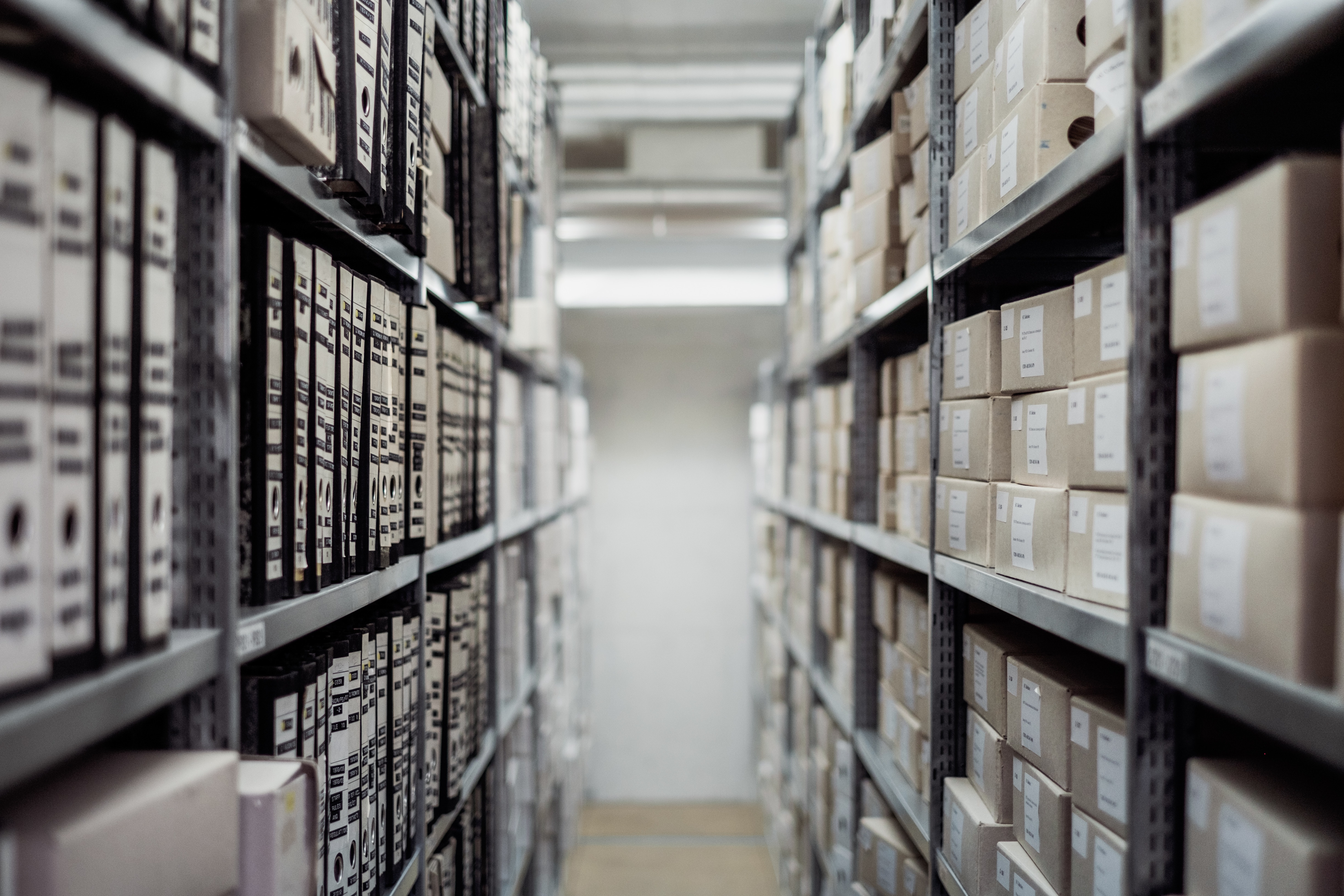 Rows of archive boxes and binders on shelves in a storage facility HD Wallpaper