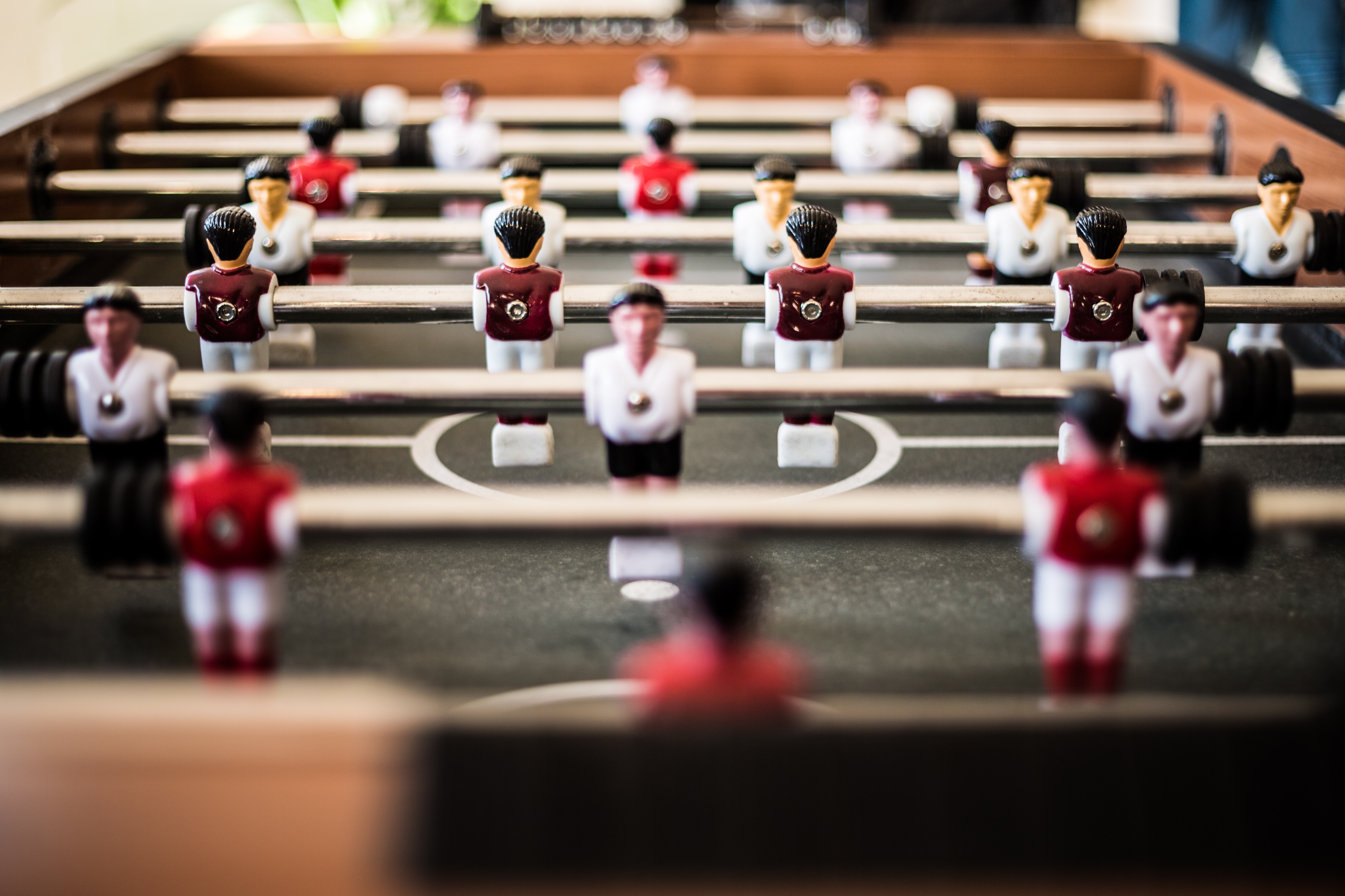 Close-up of a foosball table with blurred players HD Wallpaper