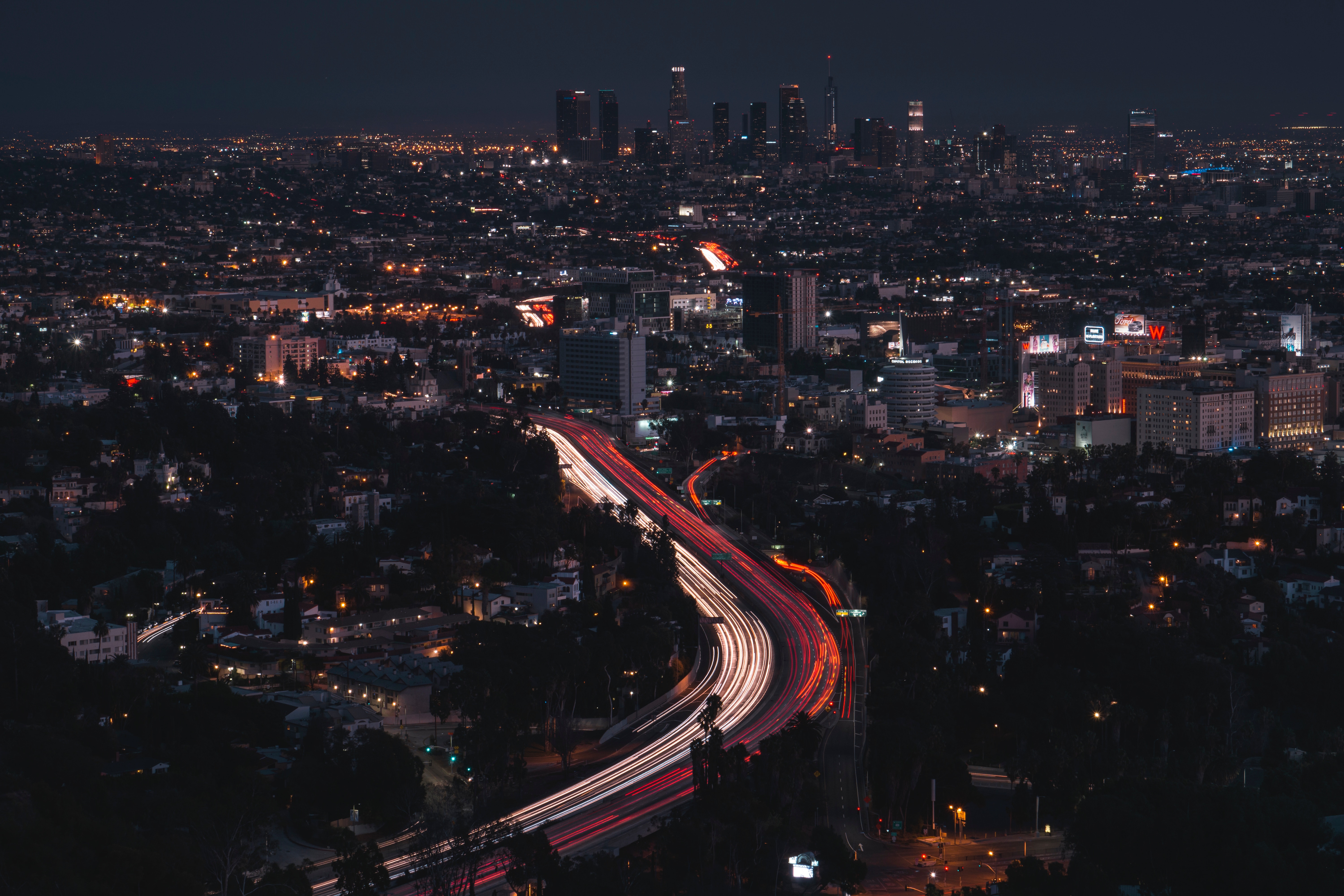 Los Angeles skyline at night with light trails on highway HD Wallpaper