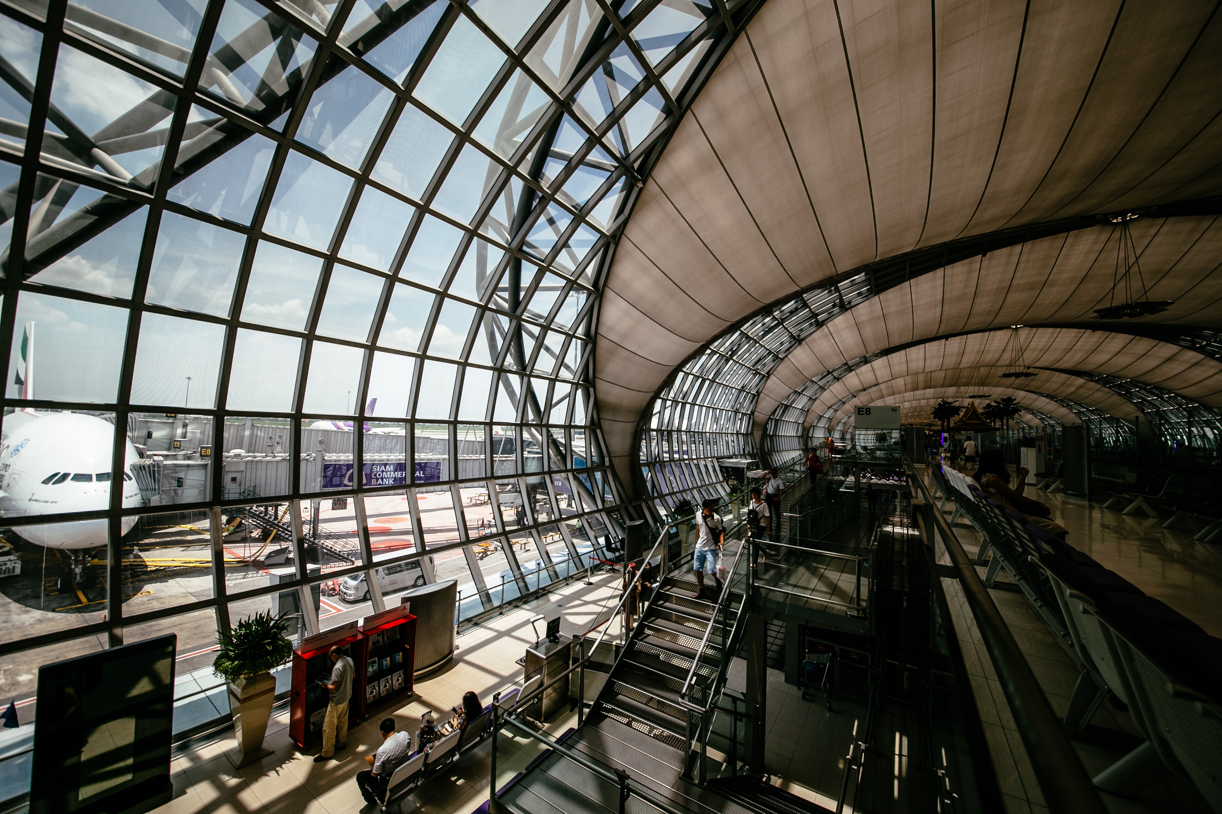 Modern airport interior with airplane at gate HD Wallpaper