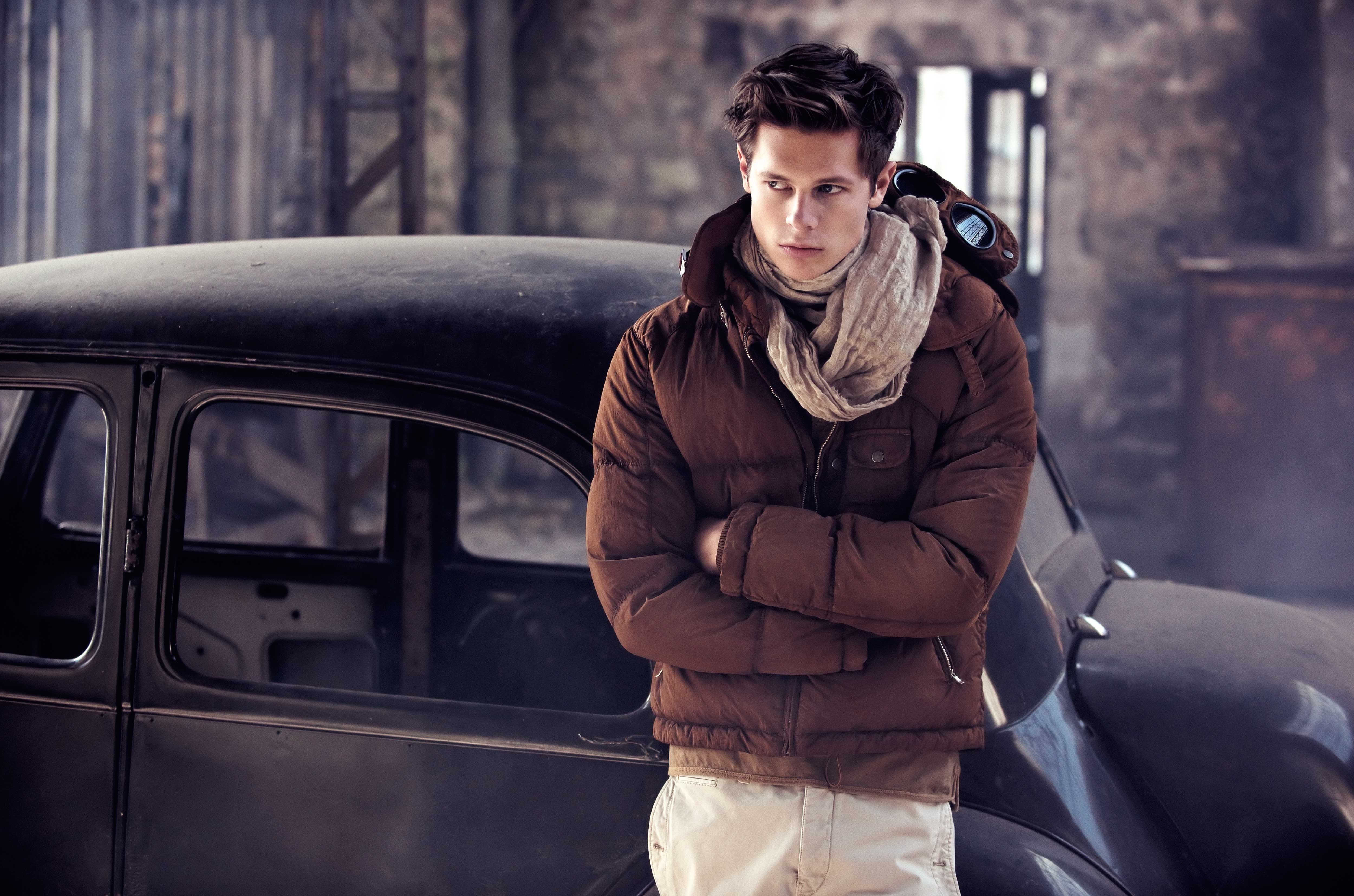 Man in winter jacket standing by a black car HD Wallpaper