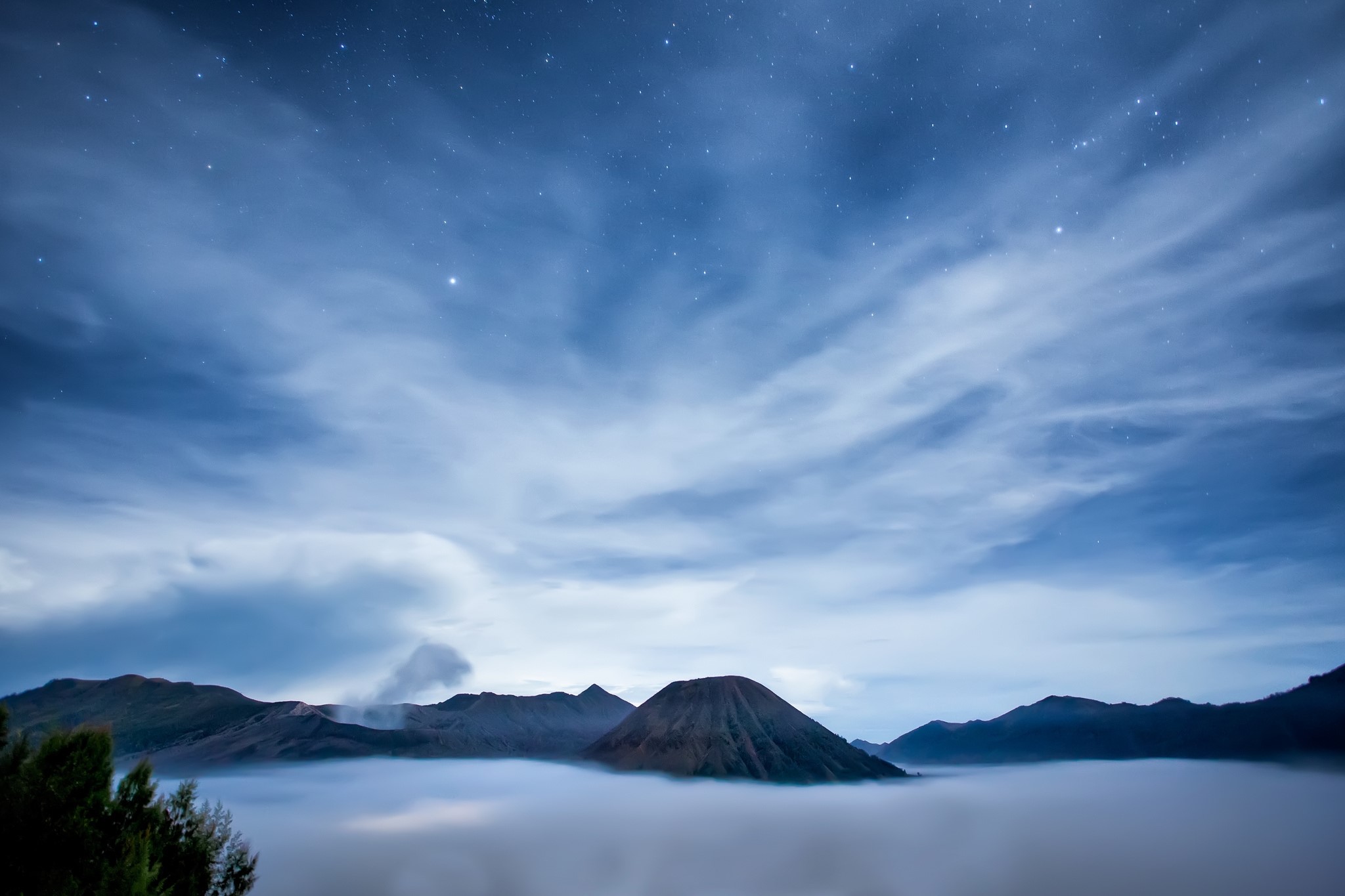 Volcanoes and clouds under a starry night sky in Indonesia HD Wallpaper