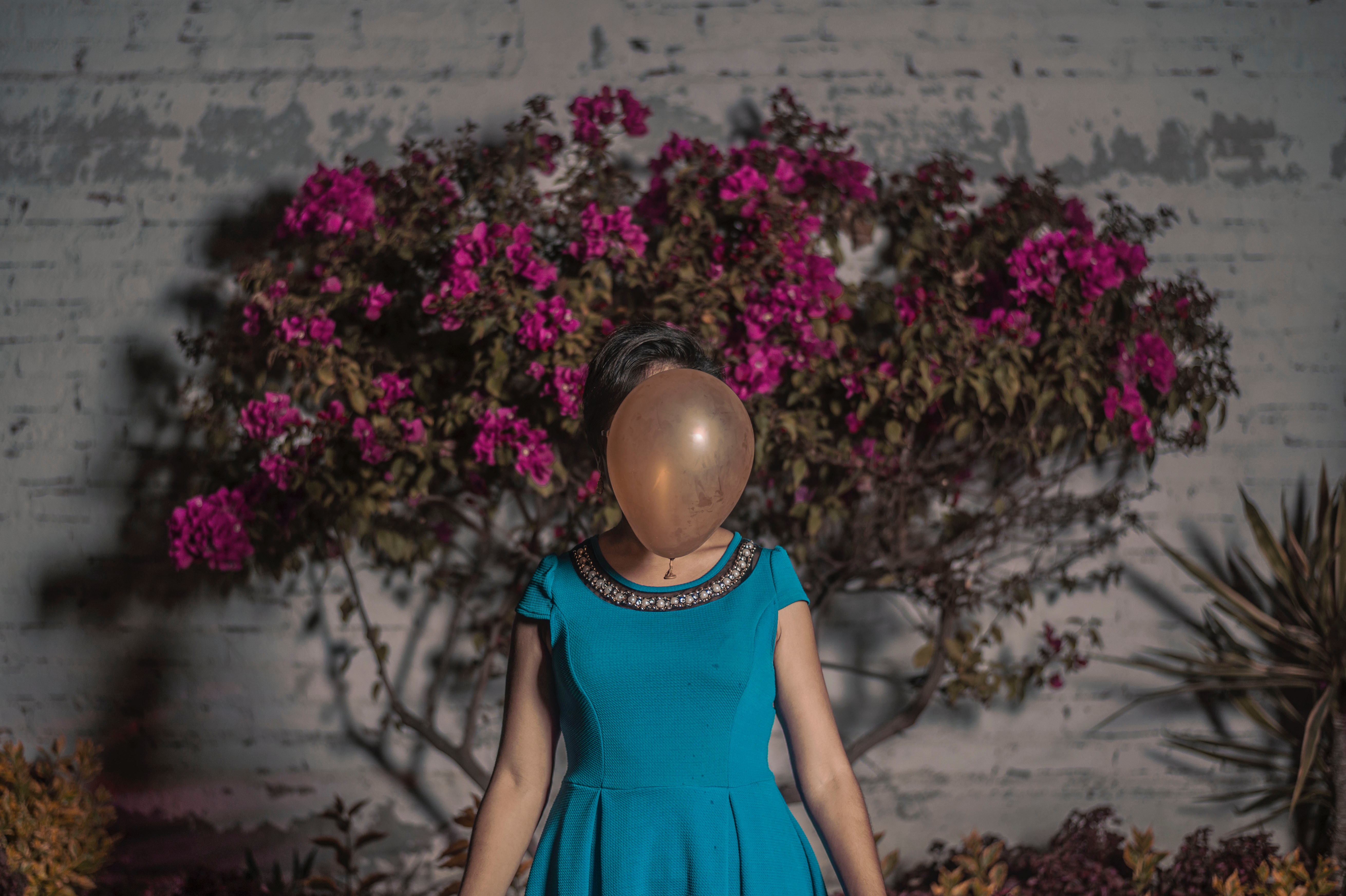 Woman in blue dress with balloon covering face HD Wallpaper