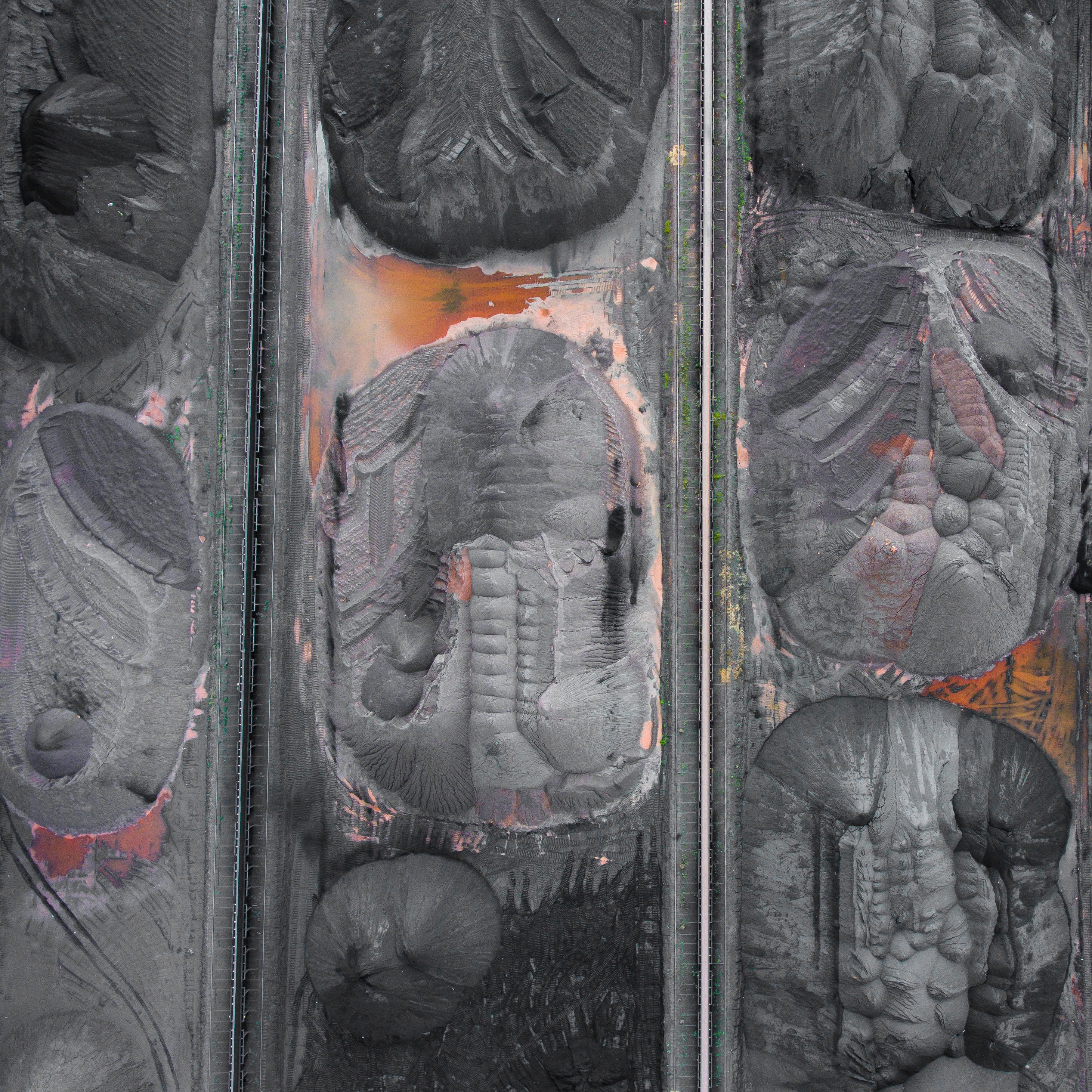 Aerial view of industrial coal piles and railway tracks HD Wallpaper