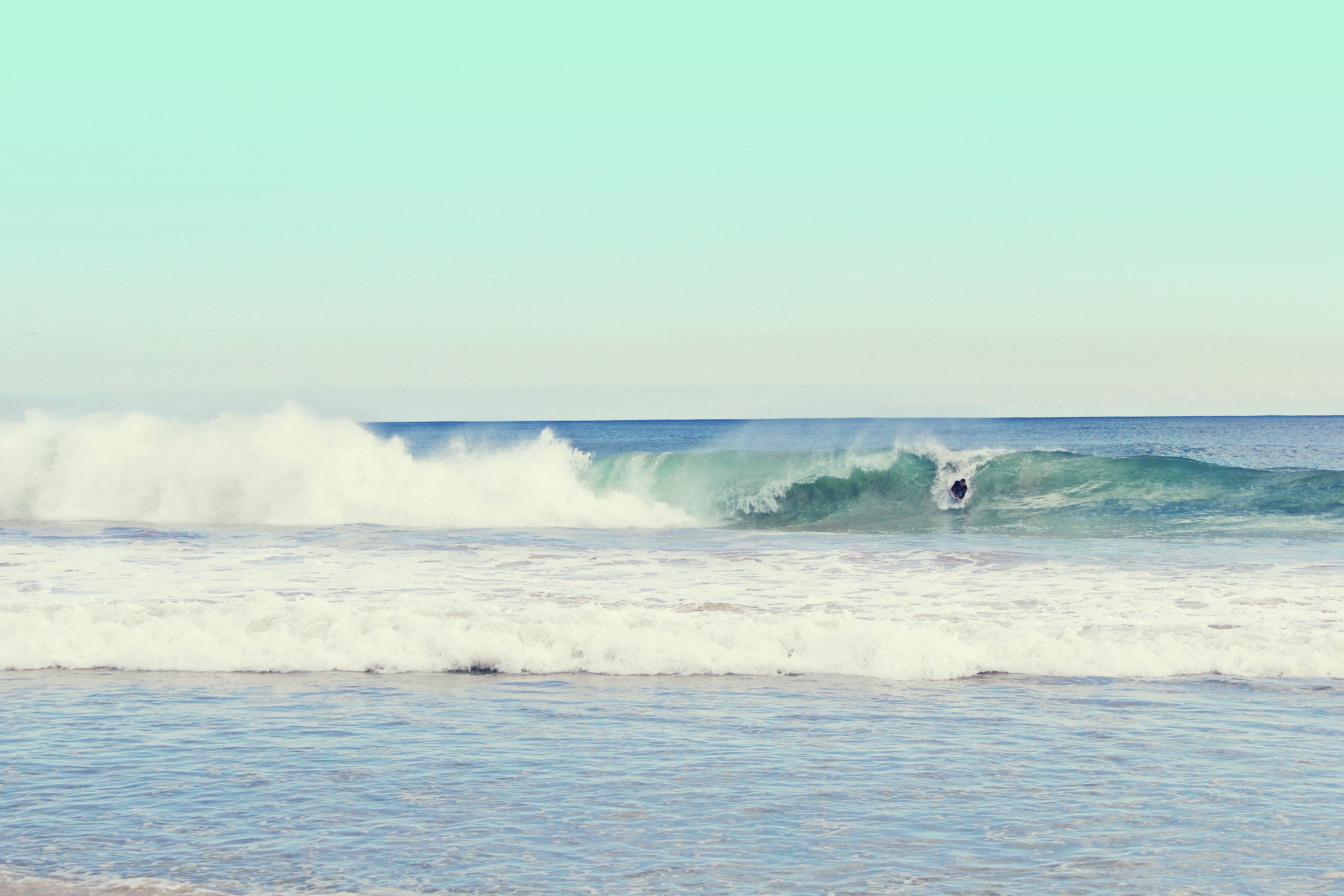 Surfer riding a wave in the ocean HD Wallpaper