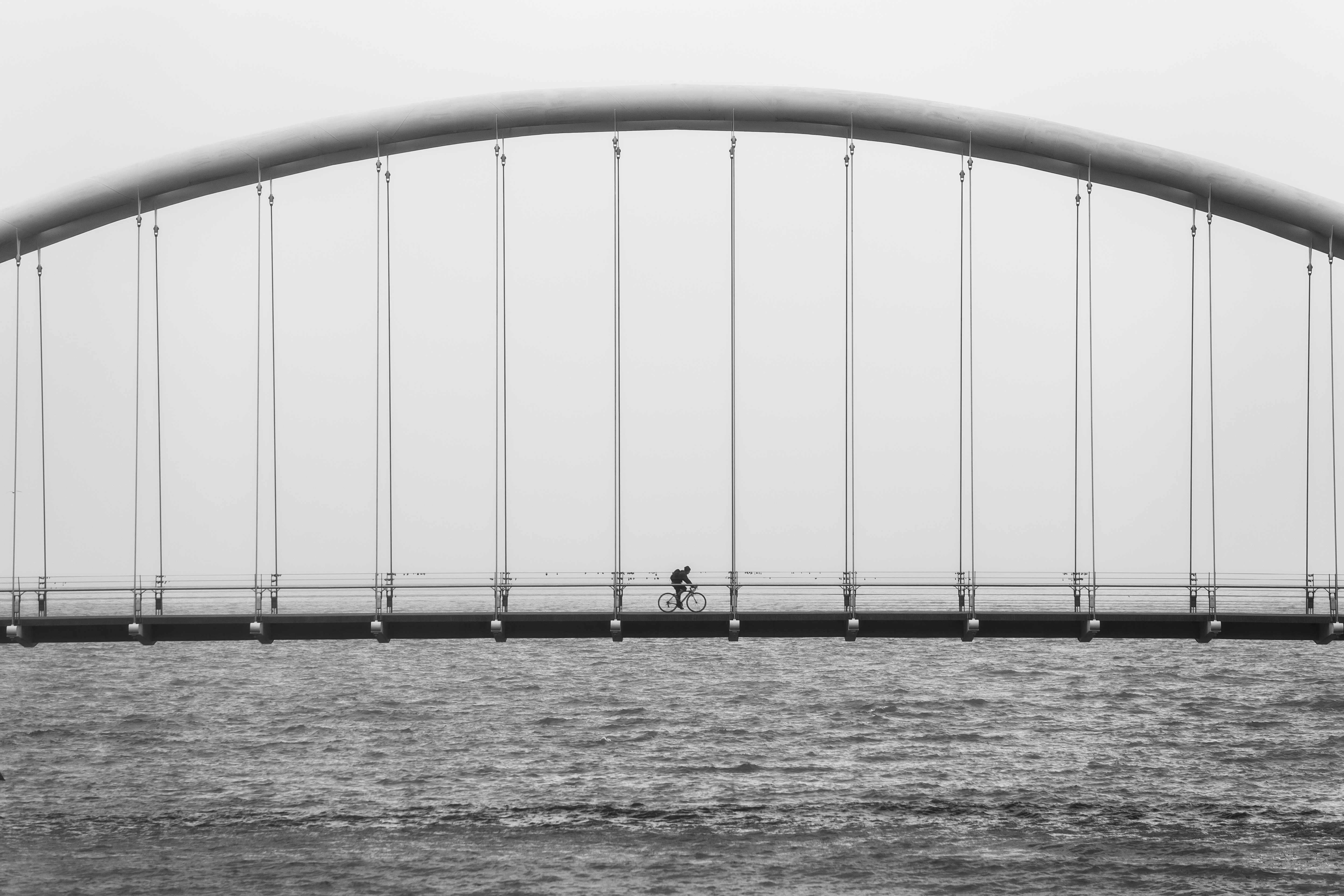 Cyclist on a Suspension Bridge Over Water HD Wallpaper