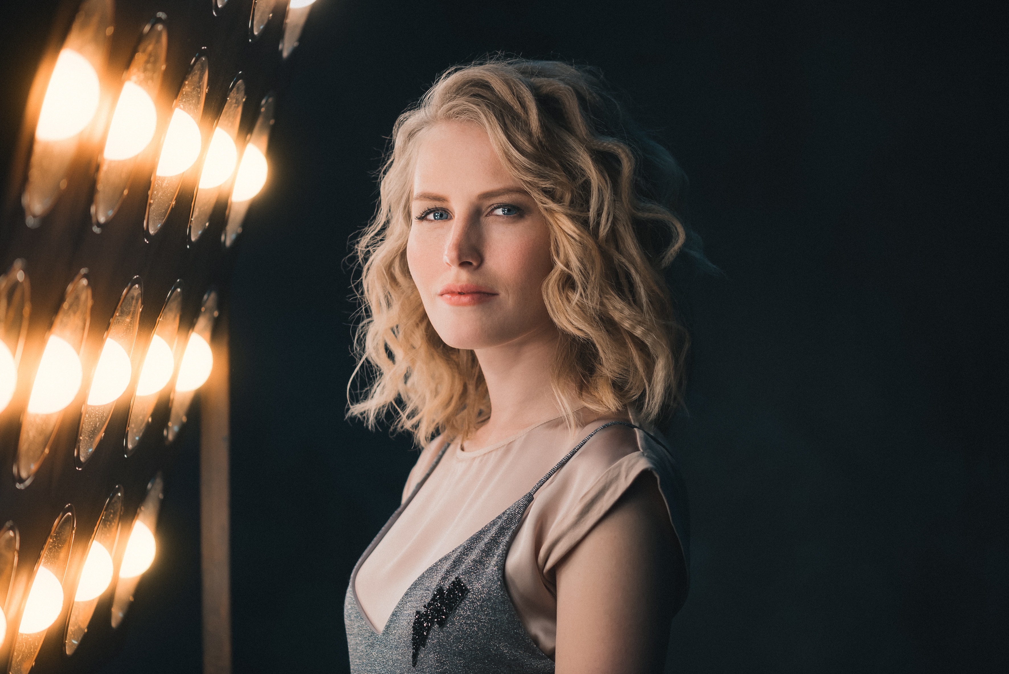 Blonde woman posing in front of stage lights HD Wallpaper