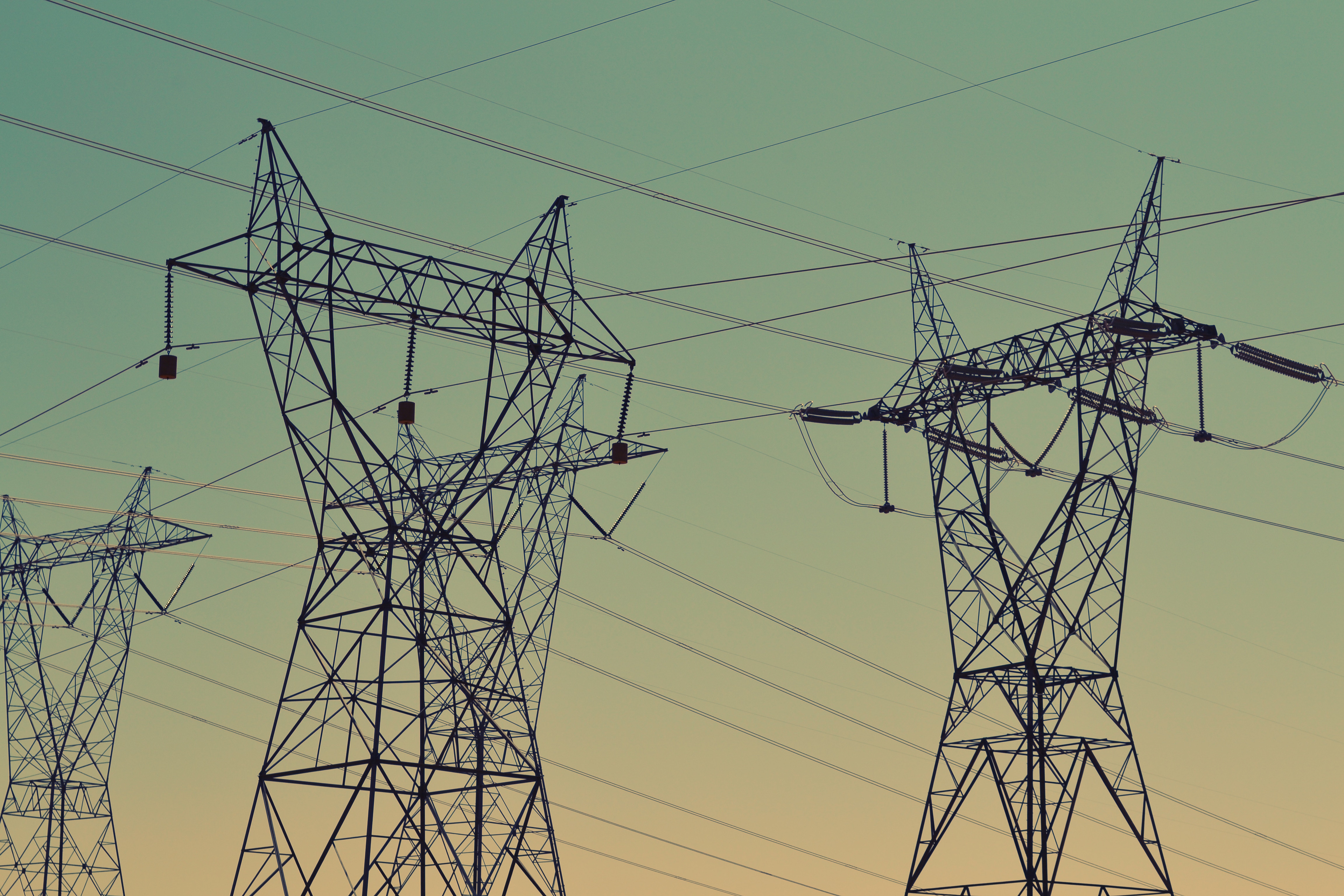 Power lines and transmission towers against a gradient sky HD Wallpaper