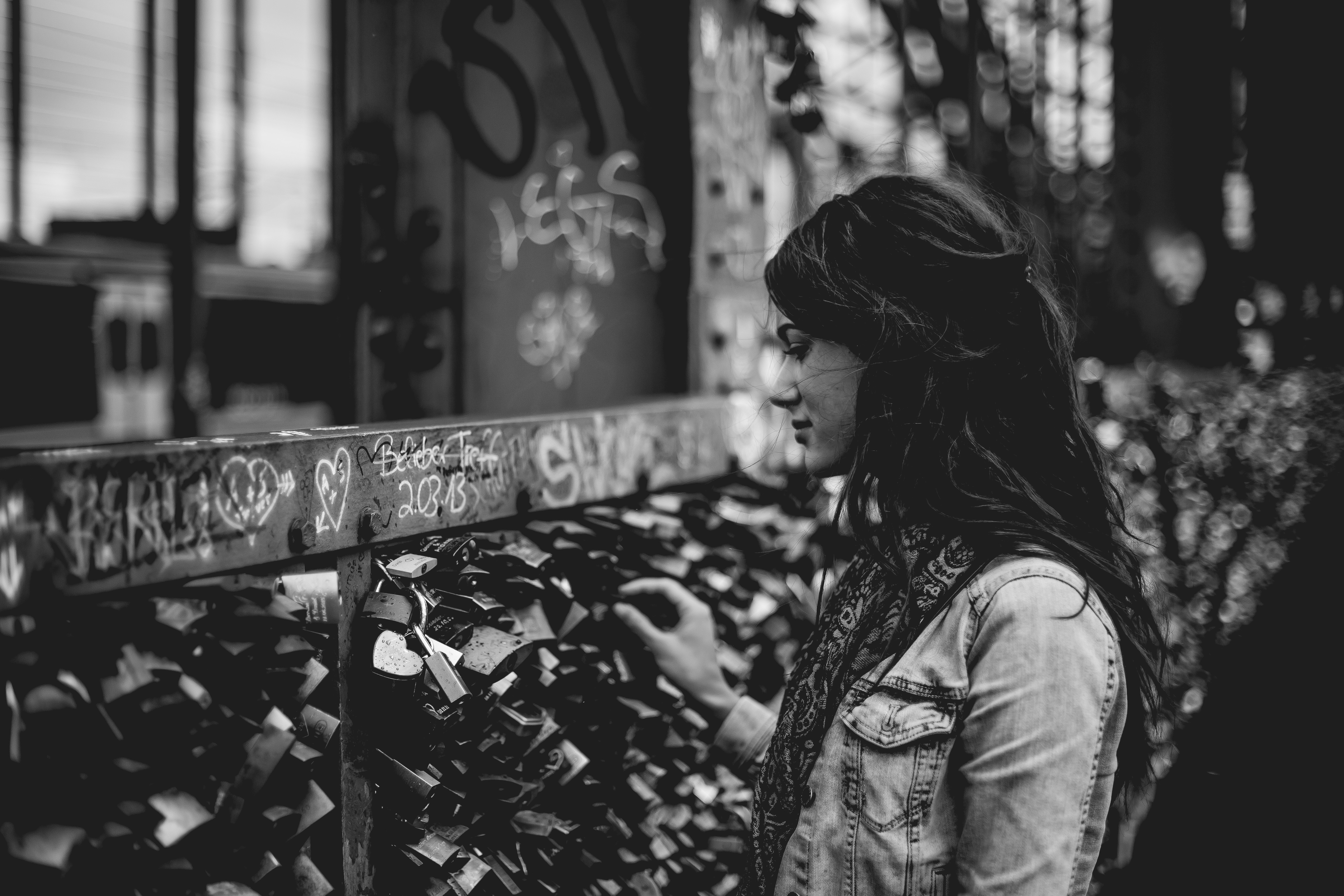Woman touching love locks on a graffiti-covered bridge HD Wallpaper