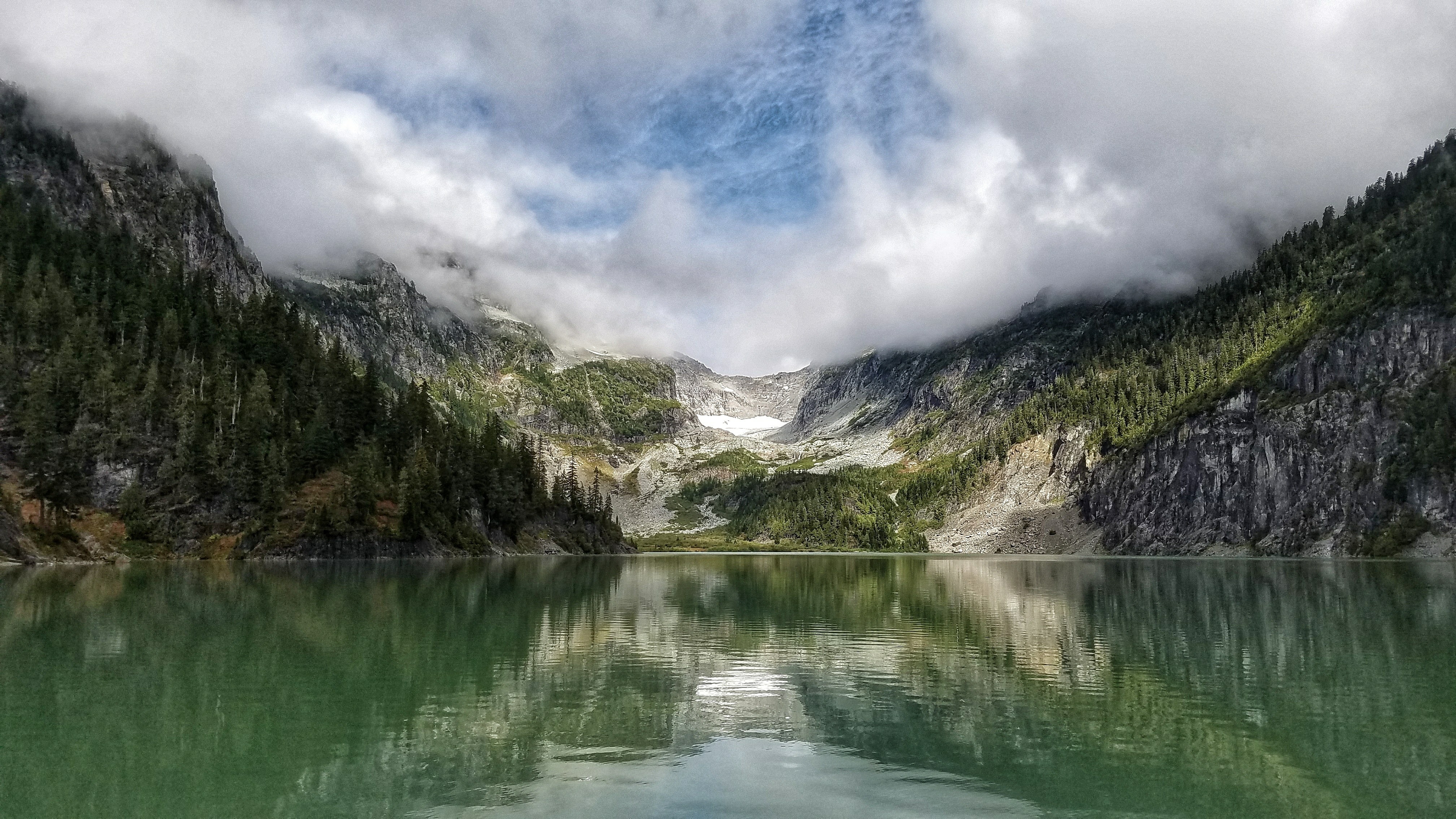Misty mountains reflected in a calm lake HD Wallpaper