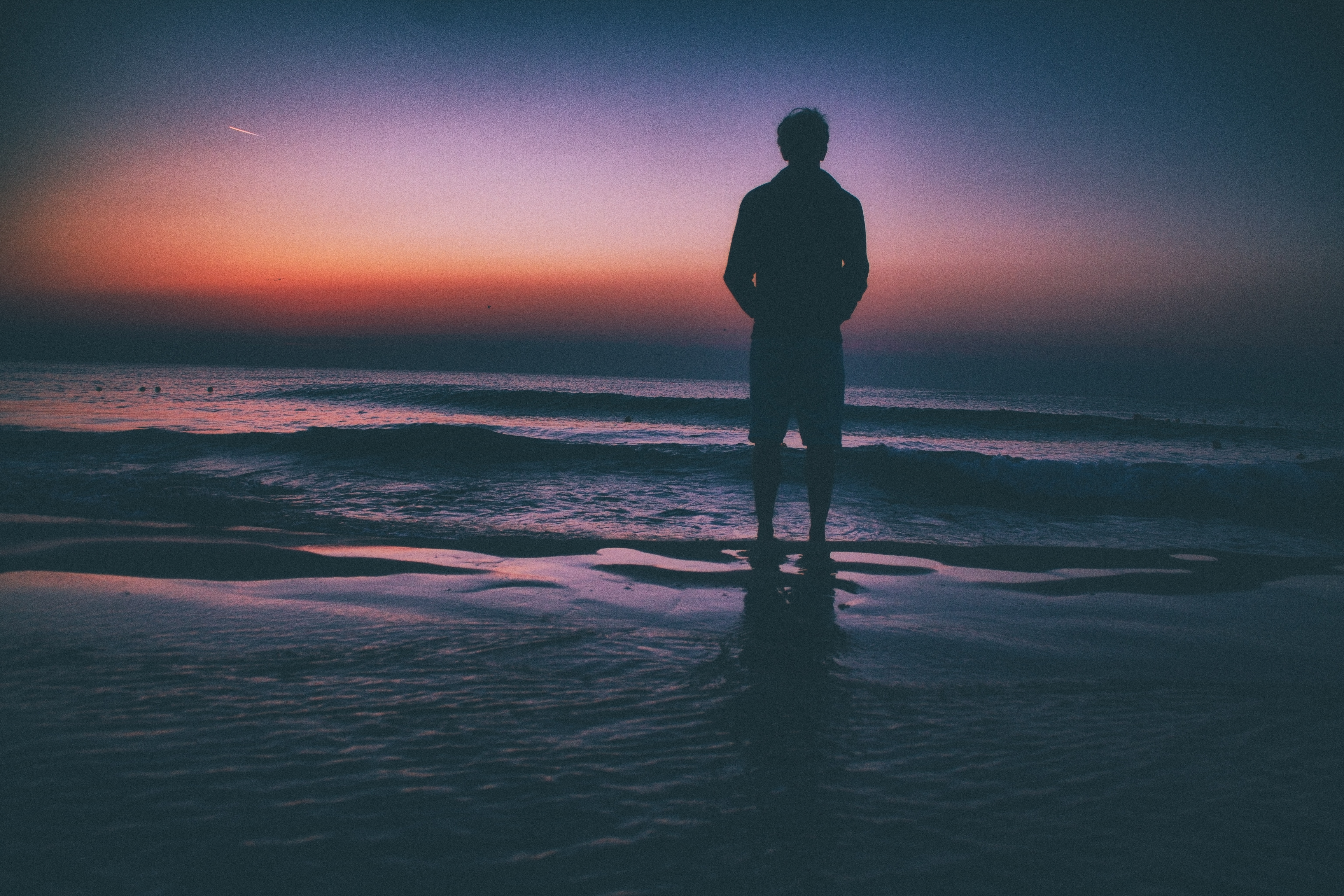 Silhouette of Man Standing by Ocean at Sunset HD Wallpaper
