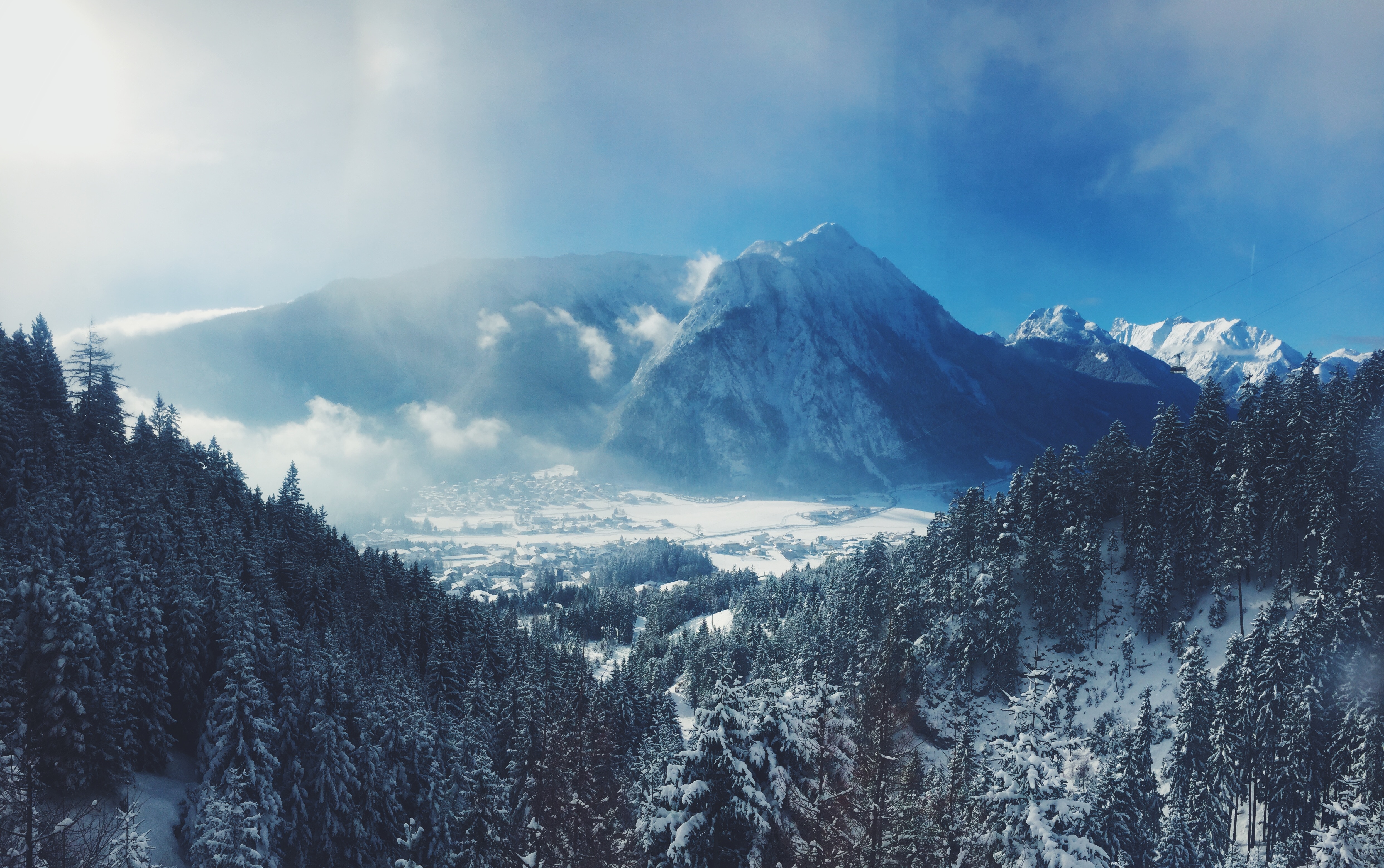 Snowy mountain range with forest and village in Austria HD Wallpaper