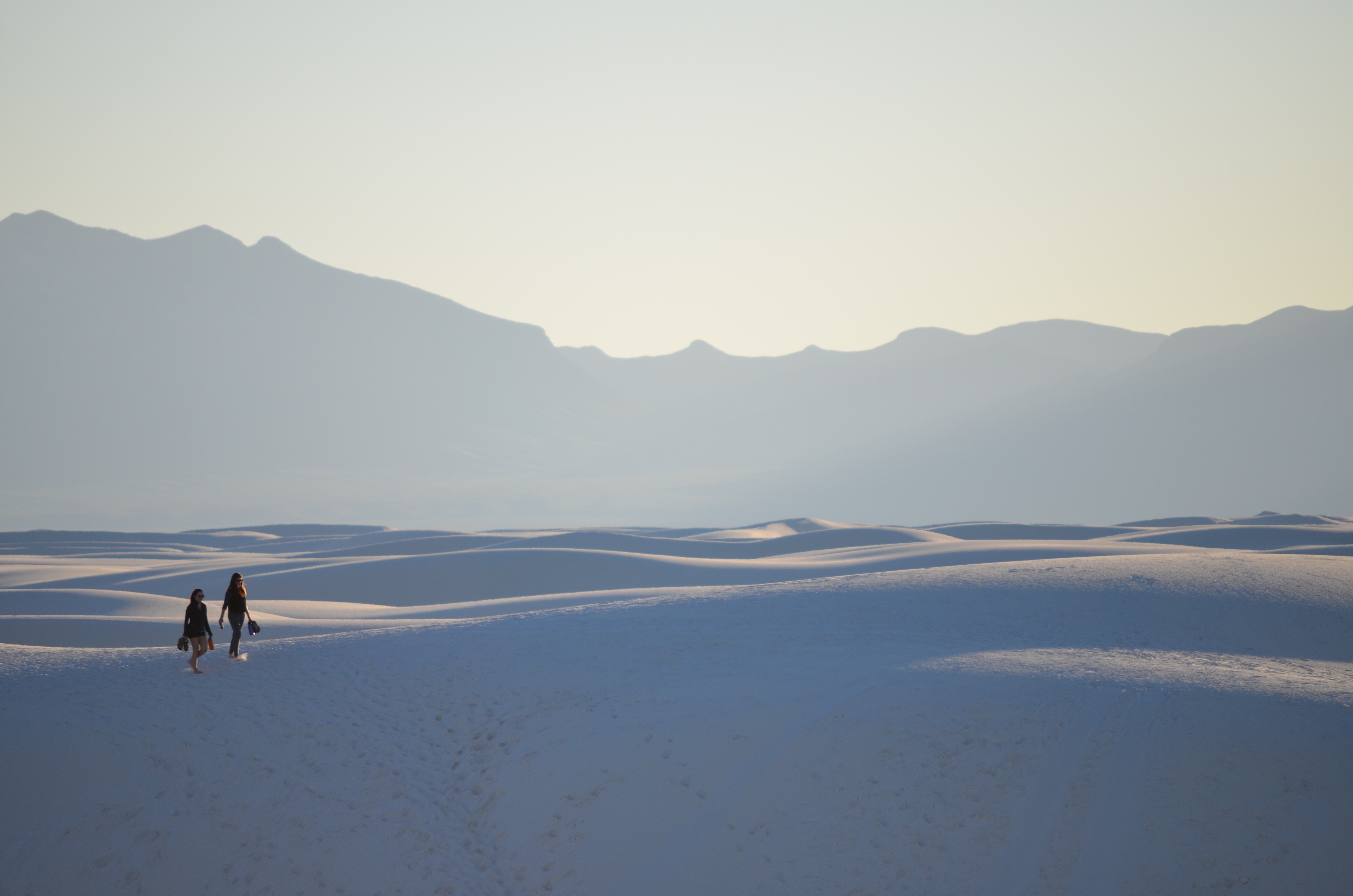 Two people walking on white sand dunes in New Mexico HD Wallpaper