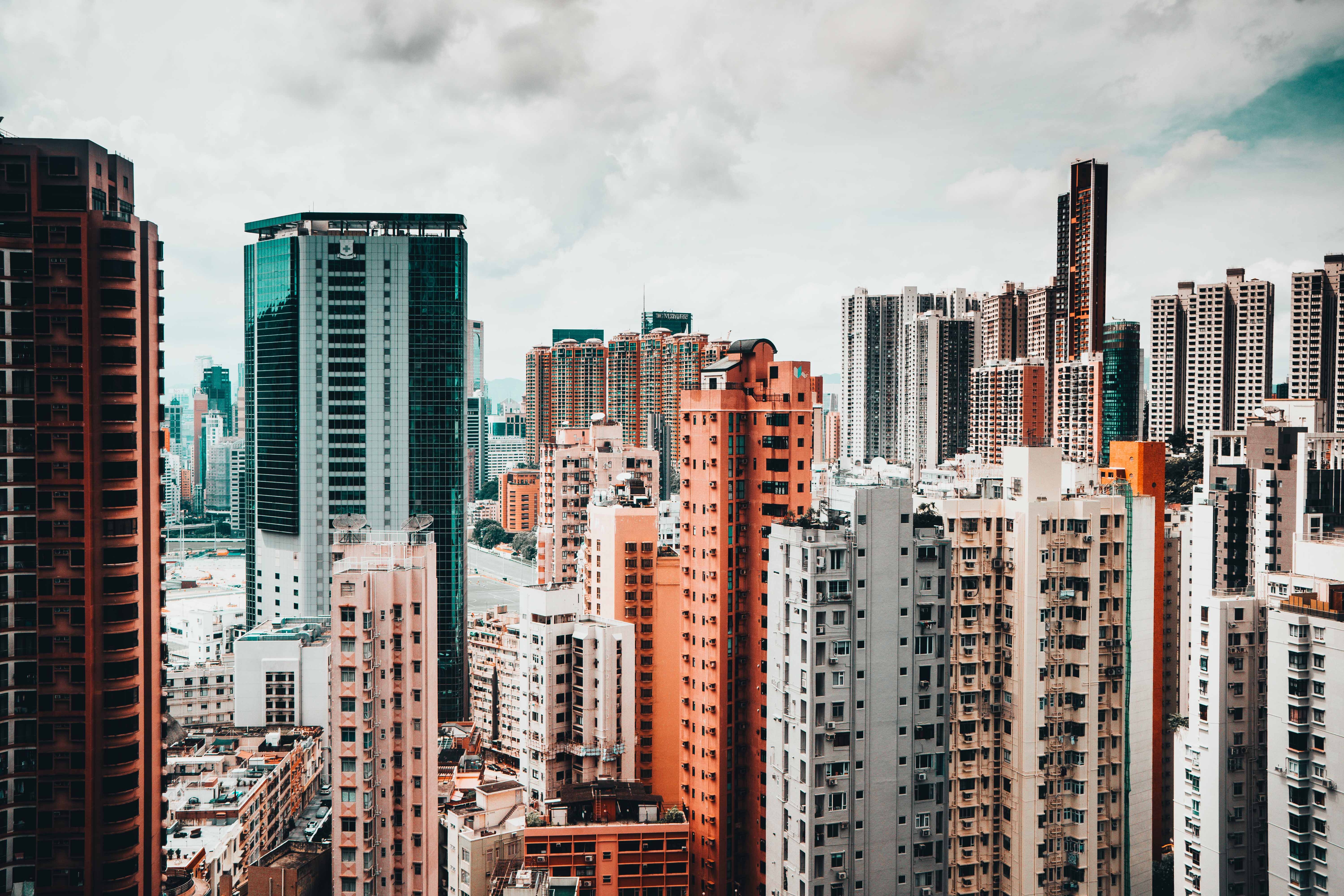 Hong Kong cityscape with numerous skyscrapers under cloudy sky HD Wallpaper