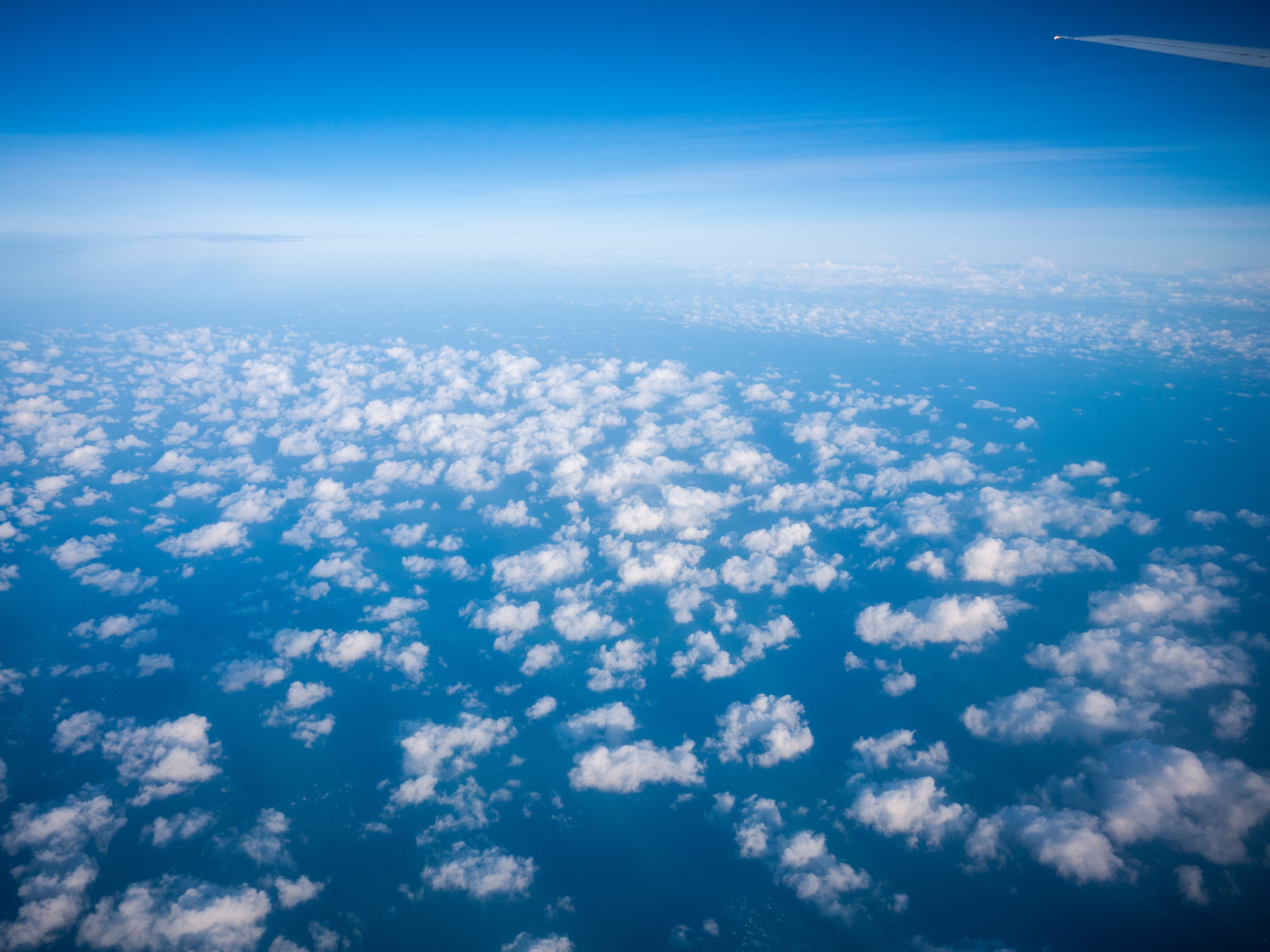 Clouds and ocean from airplane window HD Wallpaper