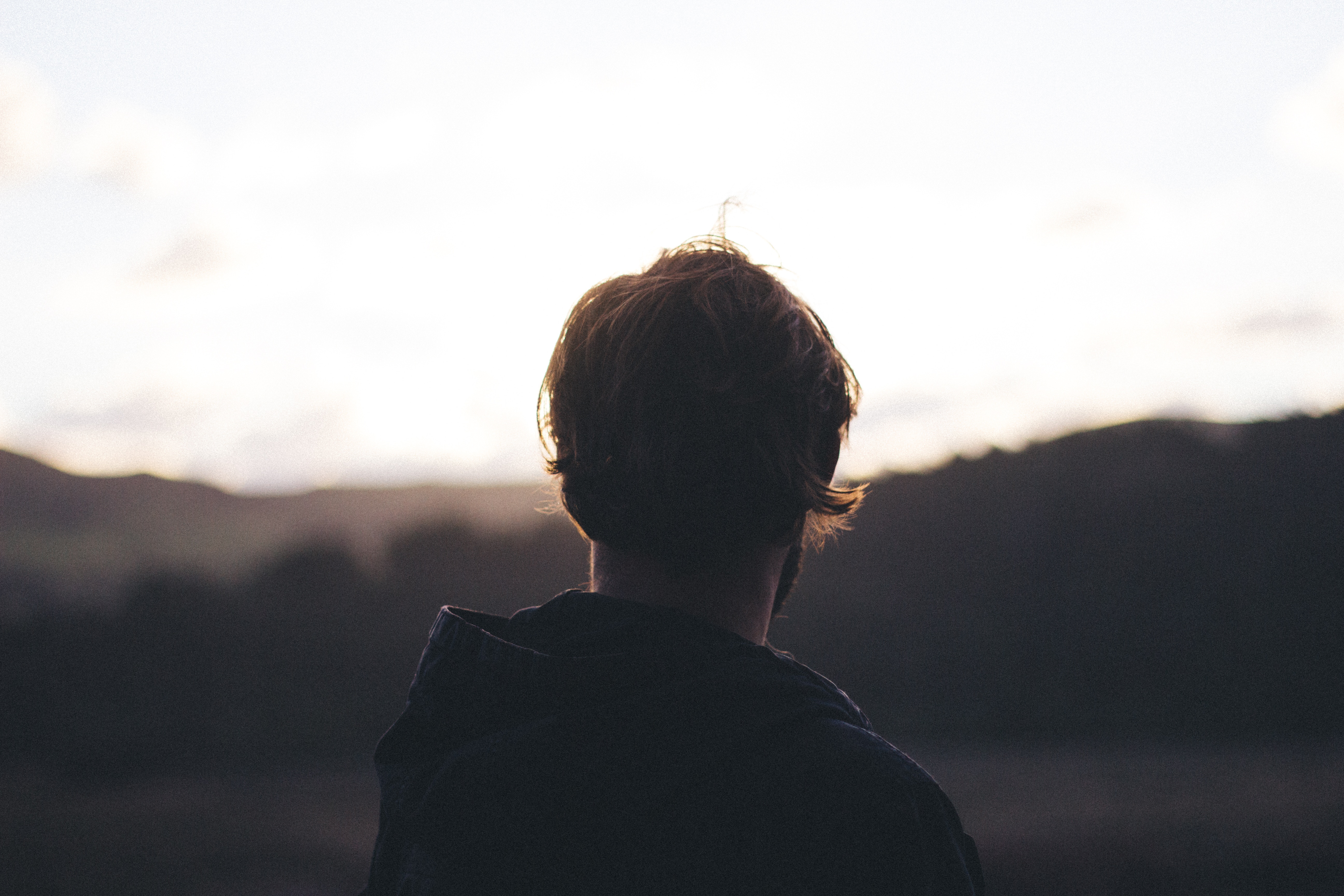 Man looking out at the horizon during golden hour HD Wallpaper