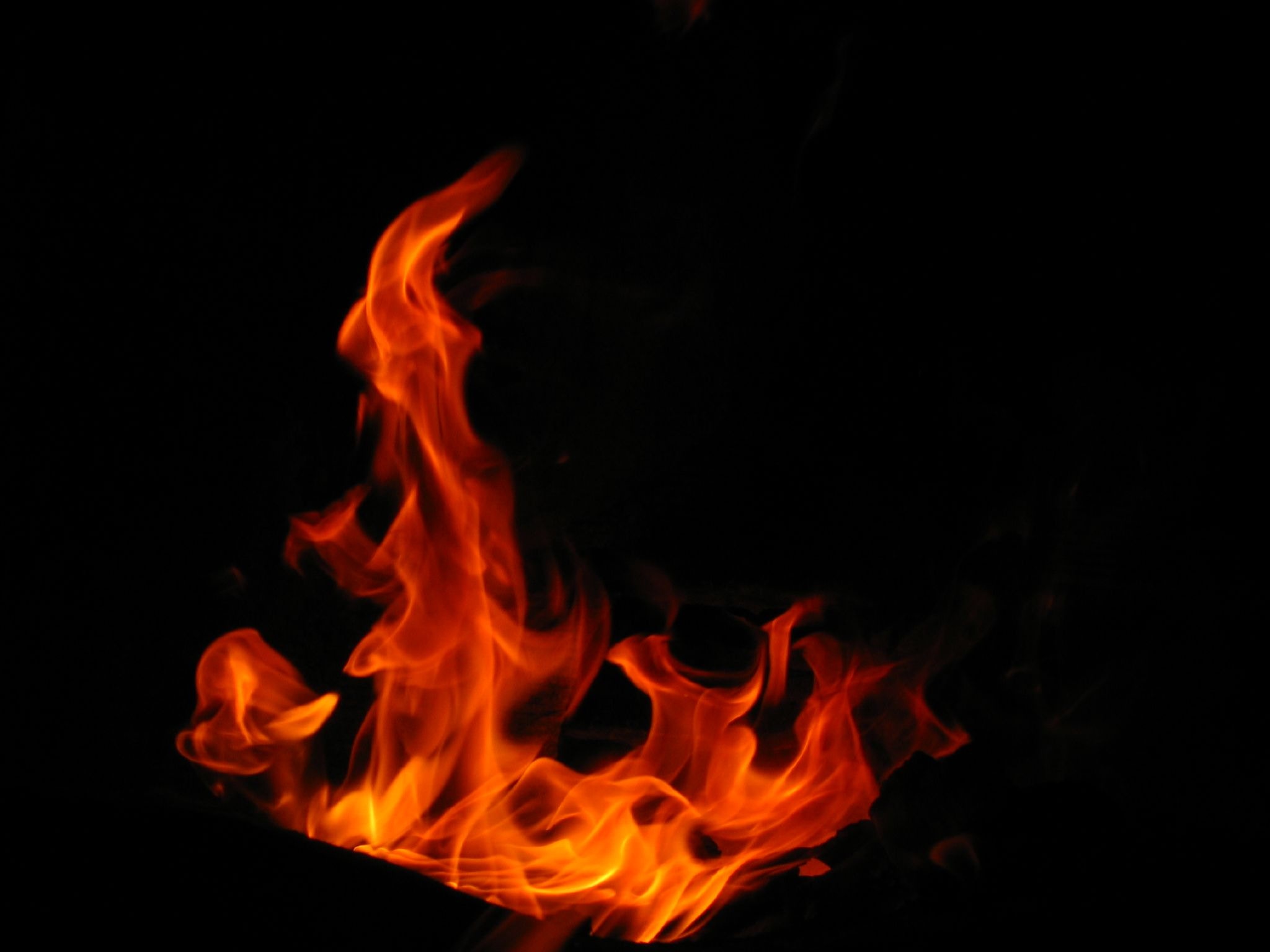 Orange flames burning brightly against a dark background HD Wallpaper