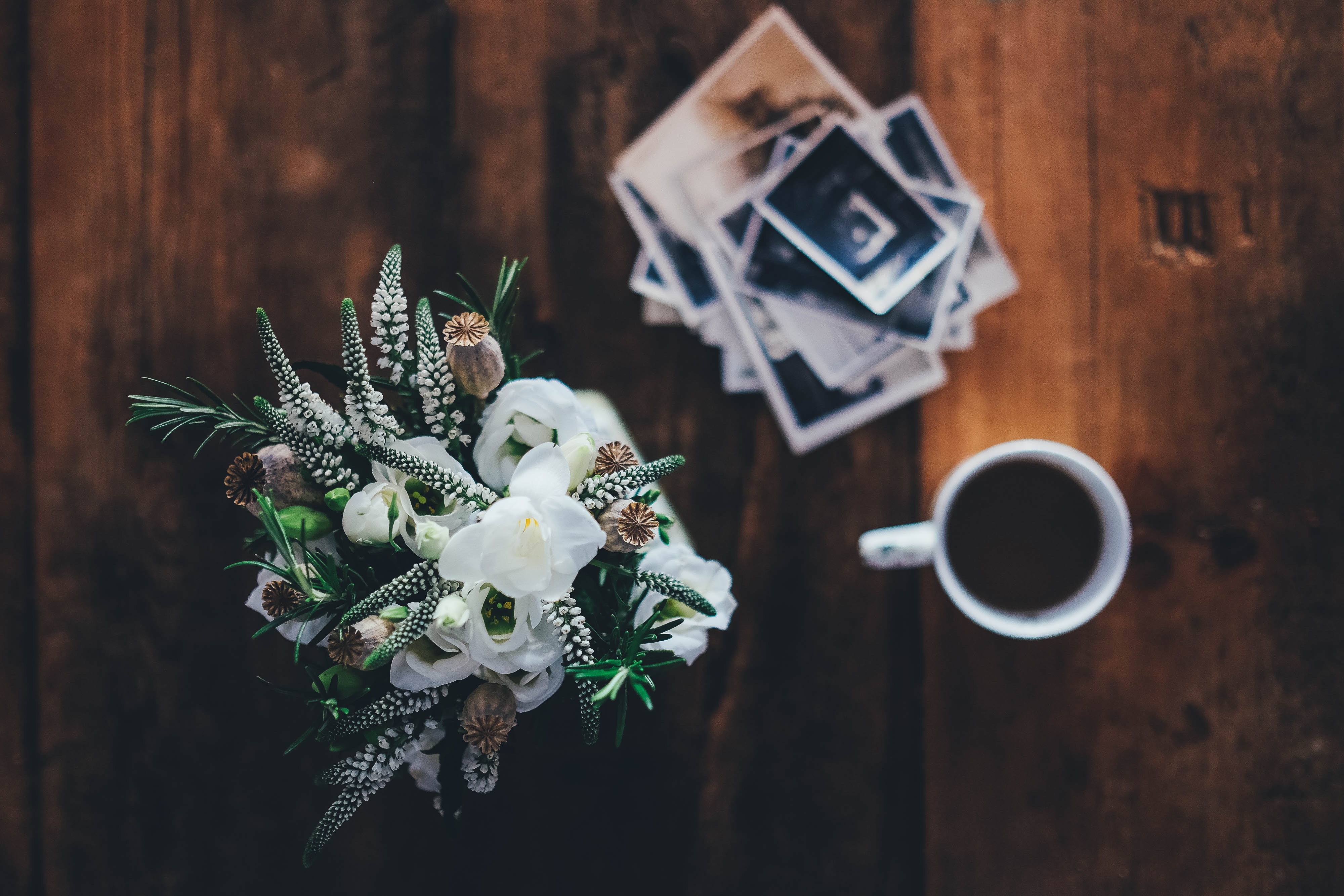 Bouquet of white flowers and photos on a wooden table HD Wallpaper