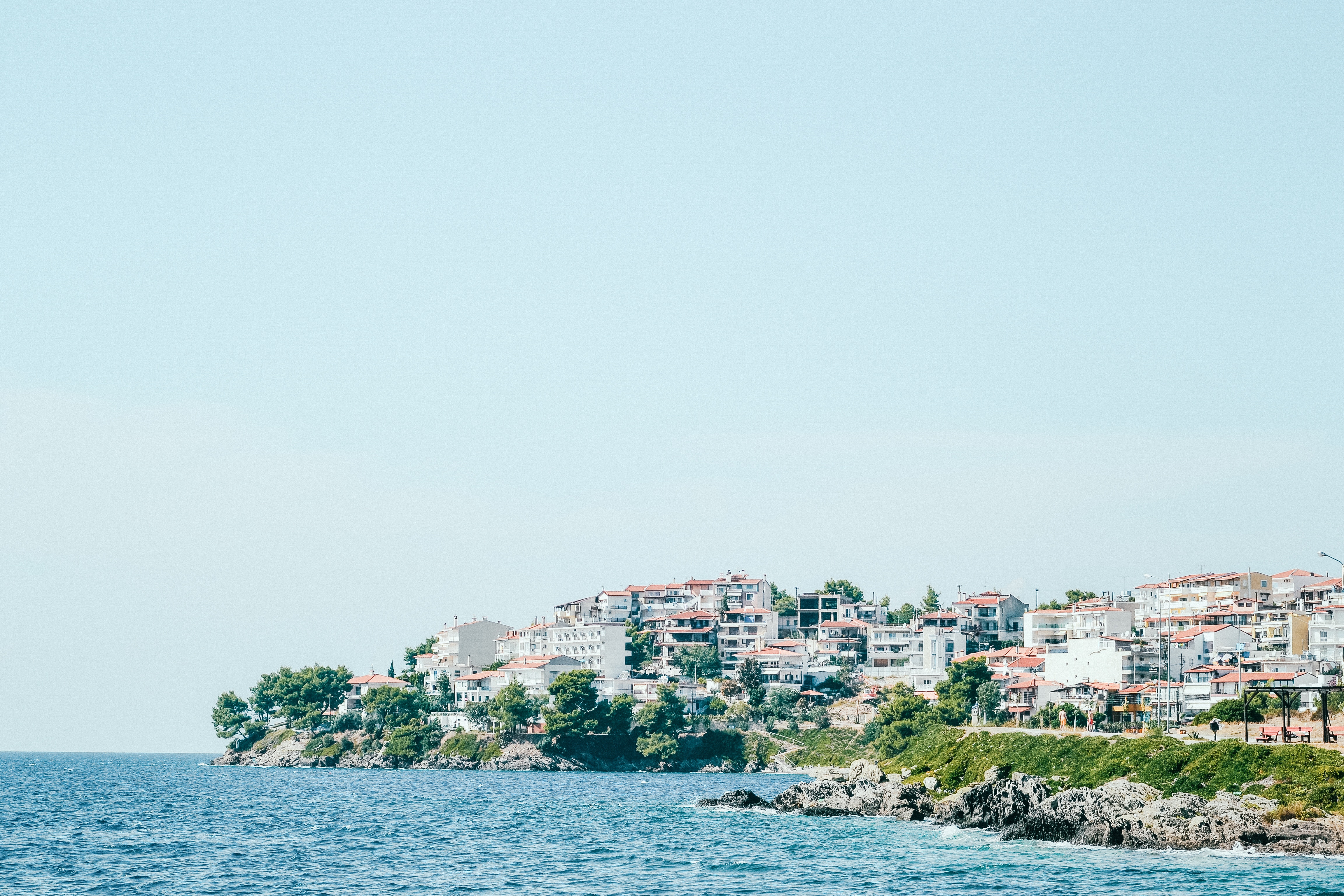 Coastal town with white buildings and blue ocean HD Wallpaper