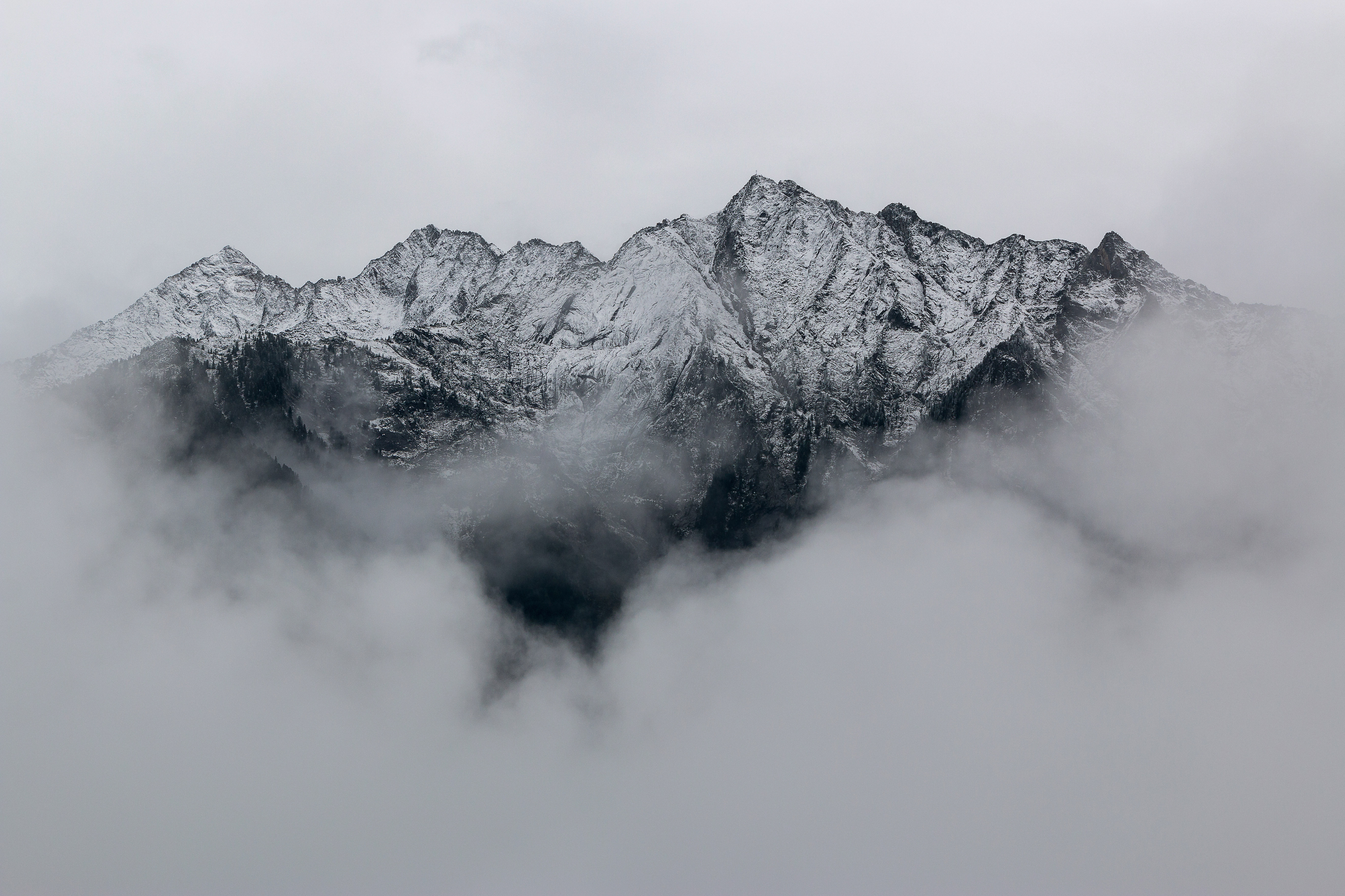 Snow-Covered Mountain Peaks Emerging Through Fog 4K HD Wallpaper