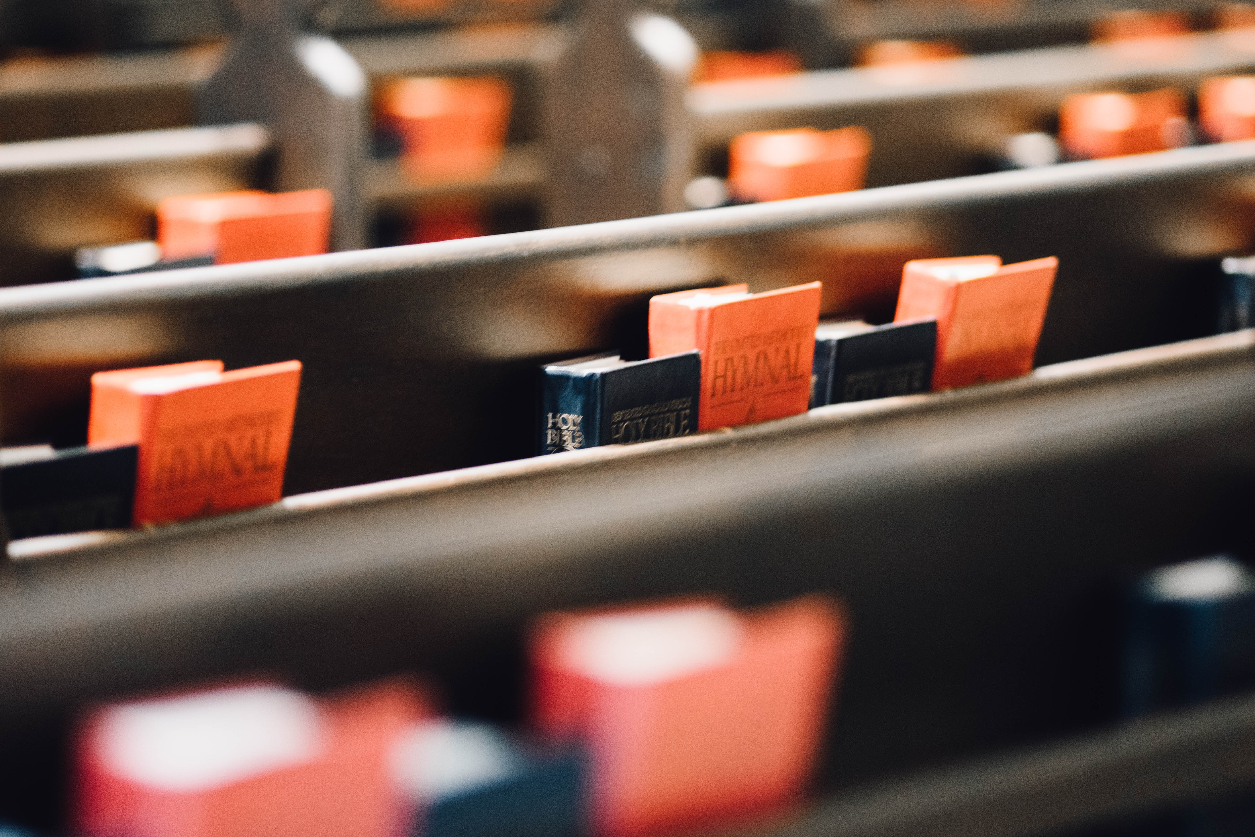 Orange and blue hymnals on church pews HD Wallpaper