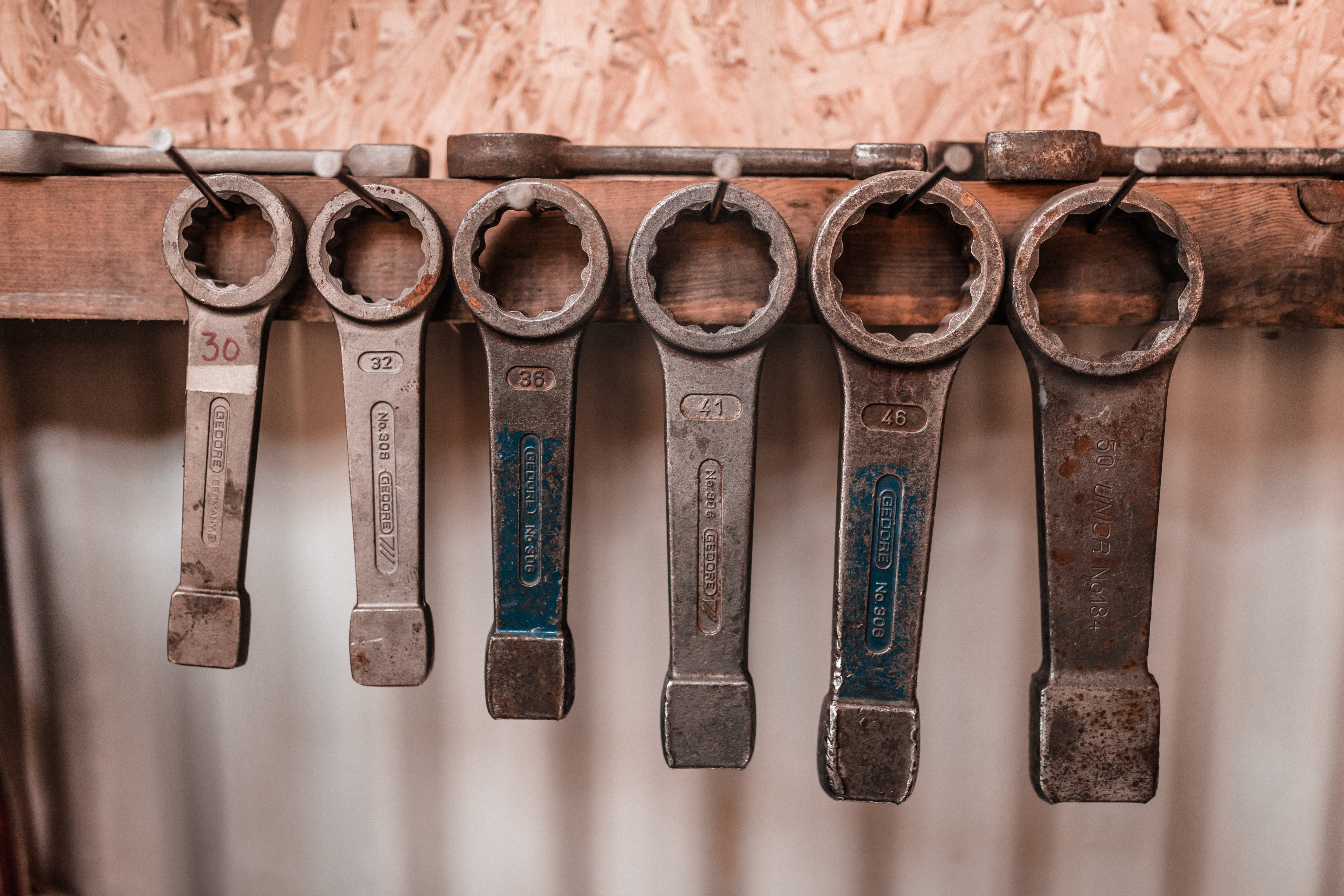 Assortment of large metal wrenches hanging on a wooden board HD Wallpaper