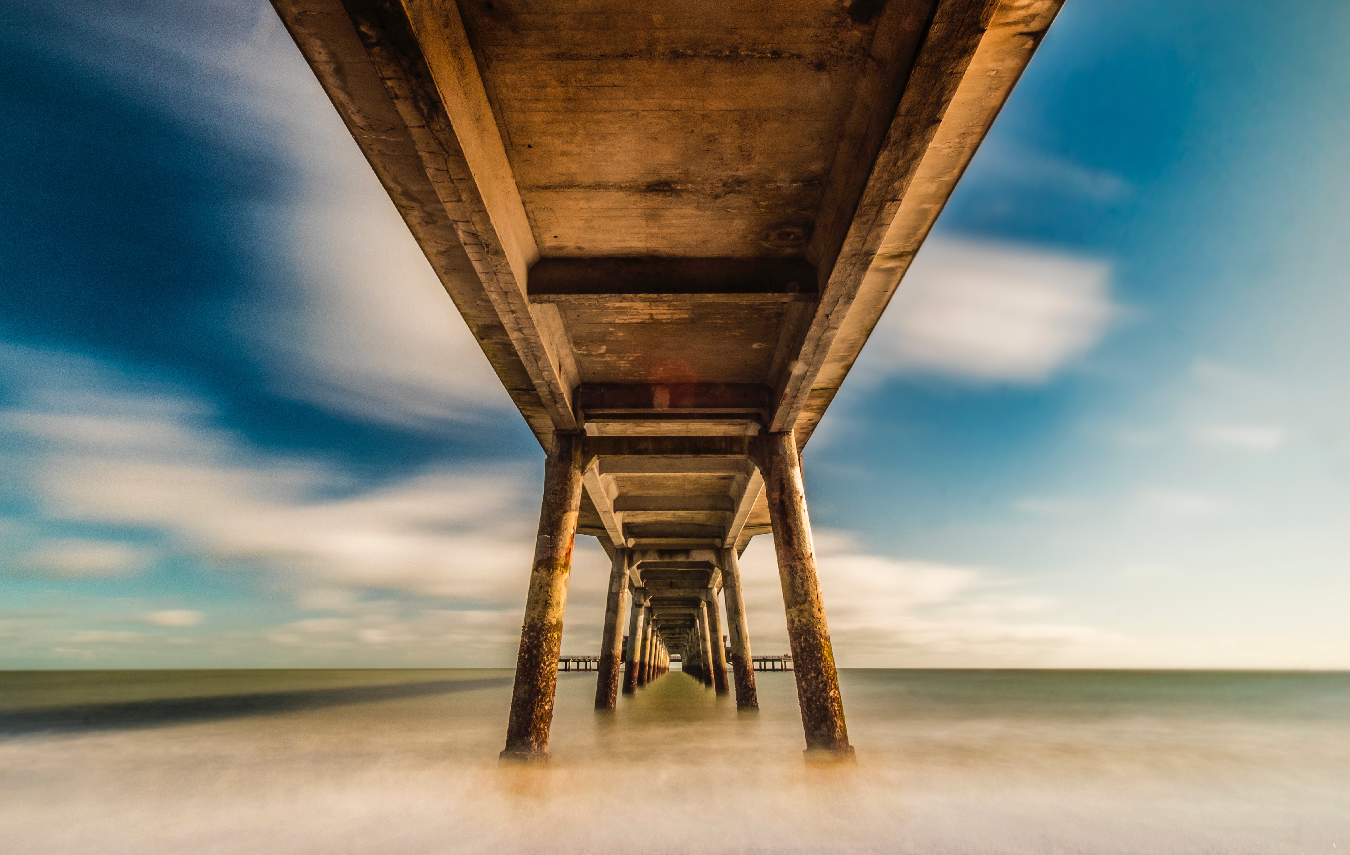 Long exposure of a pier over the ocean HD Wallpaper