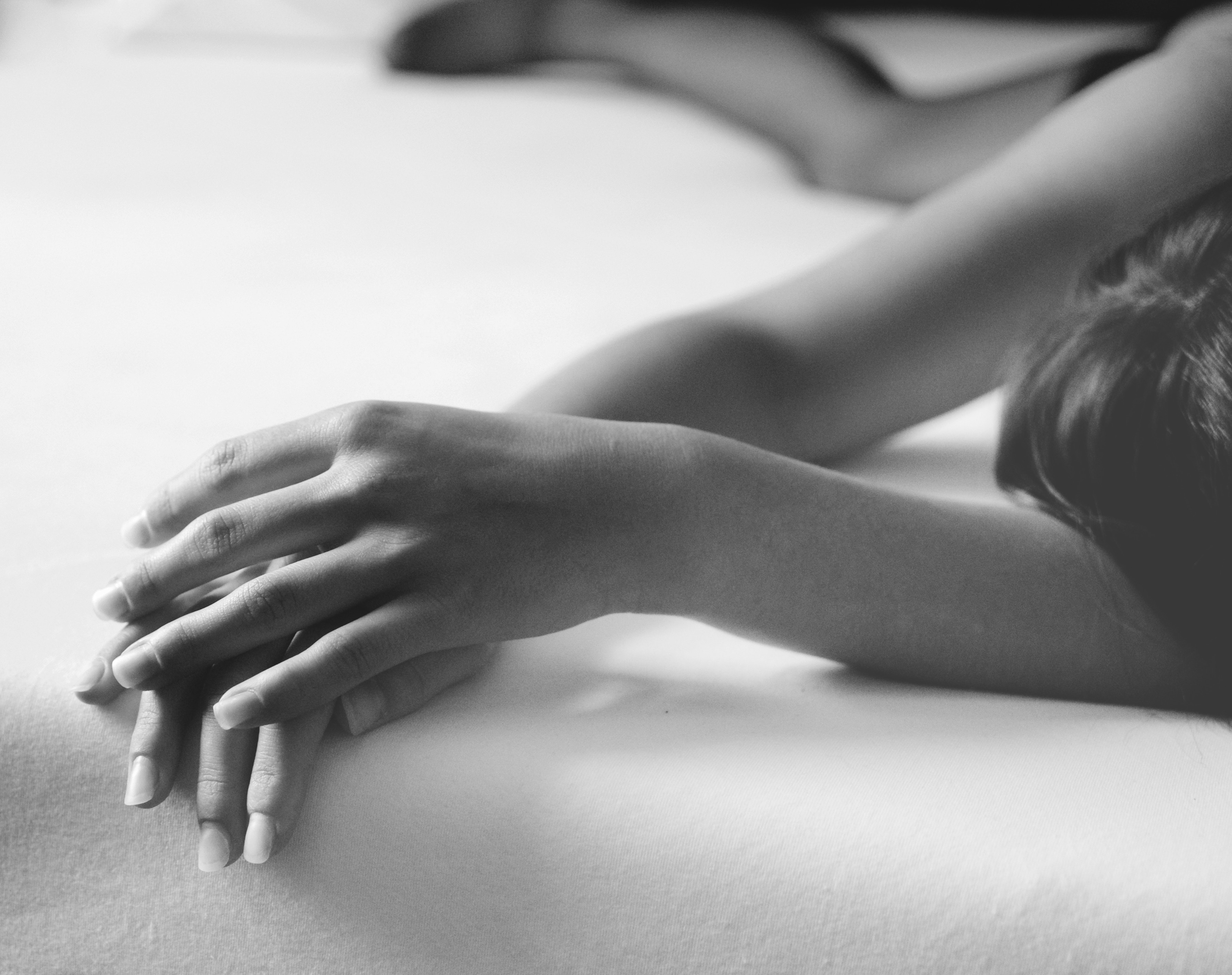 Black and white photo of a woman's hands on a bed HD Wallpaper