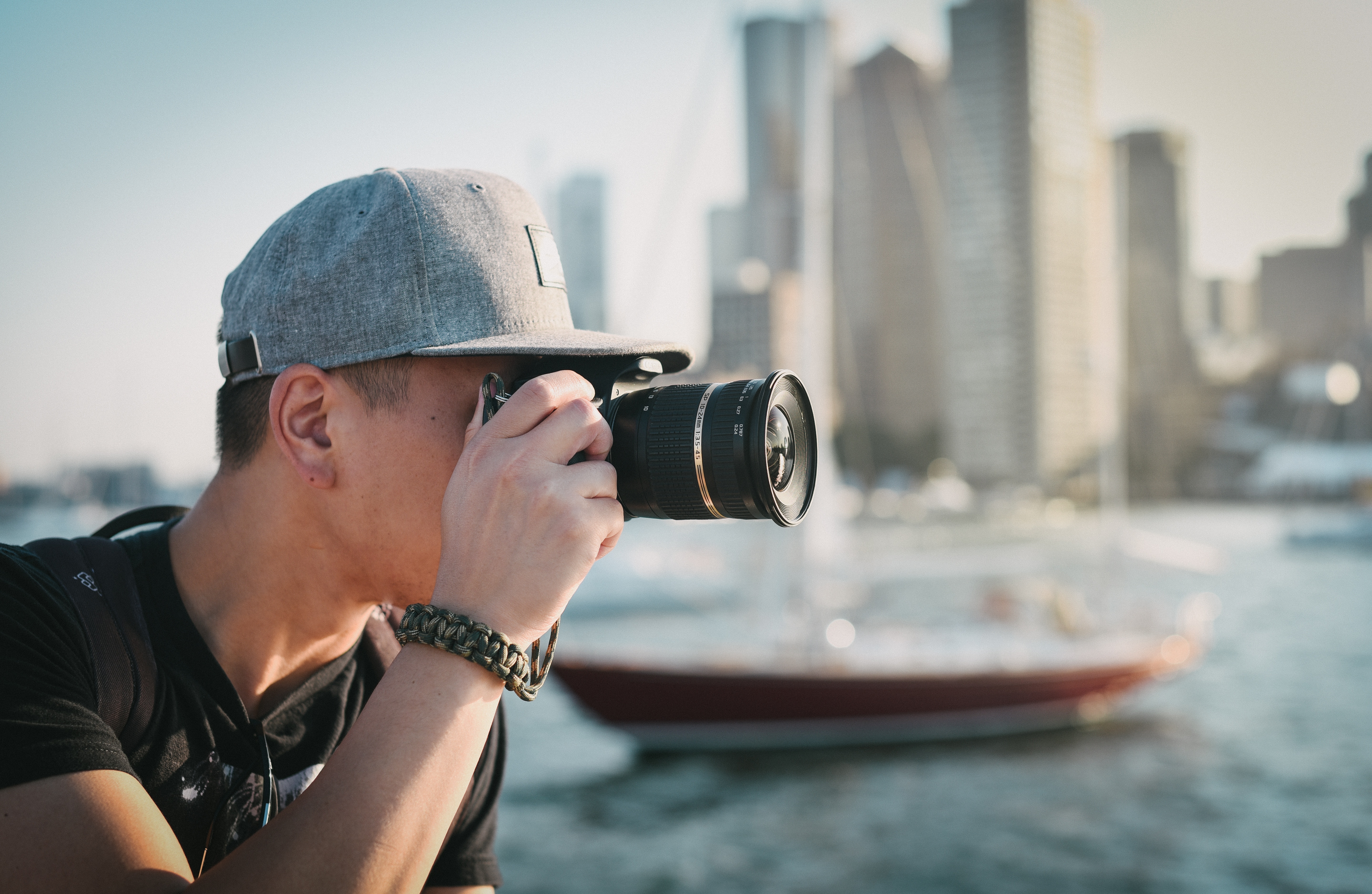 Man in cap taking photo with camera in Boston HD Wallpaper