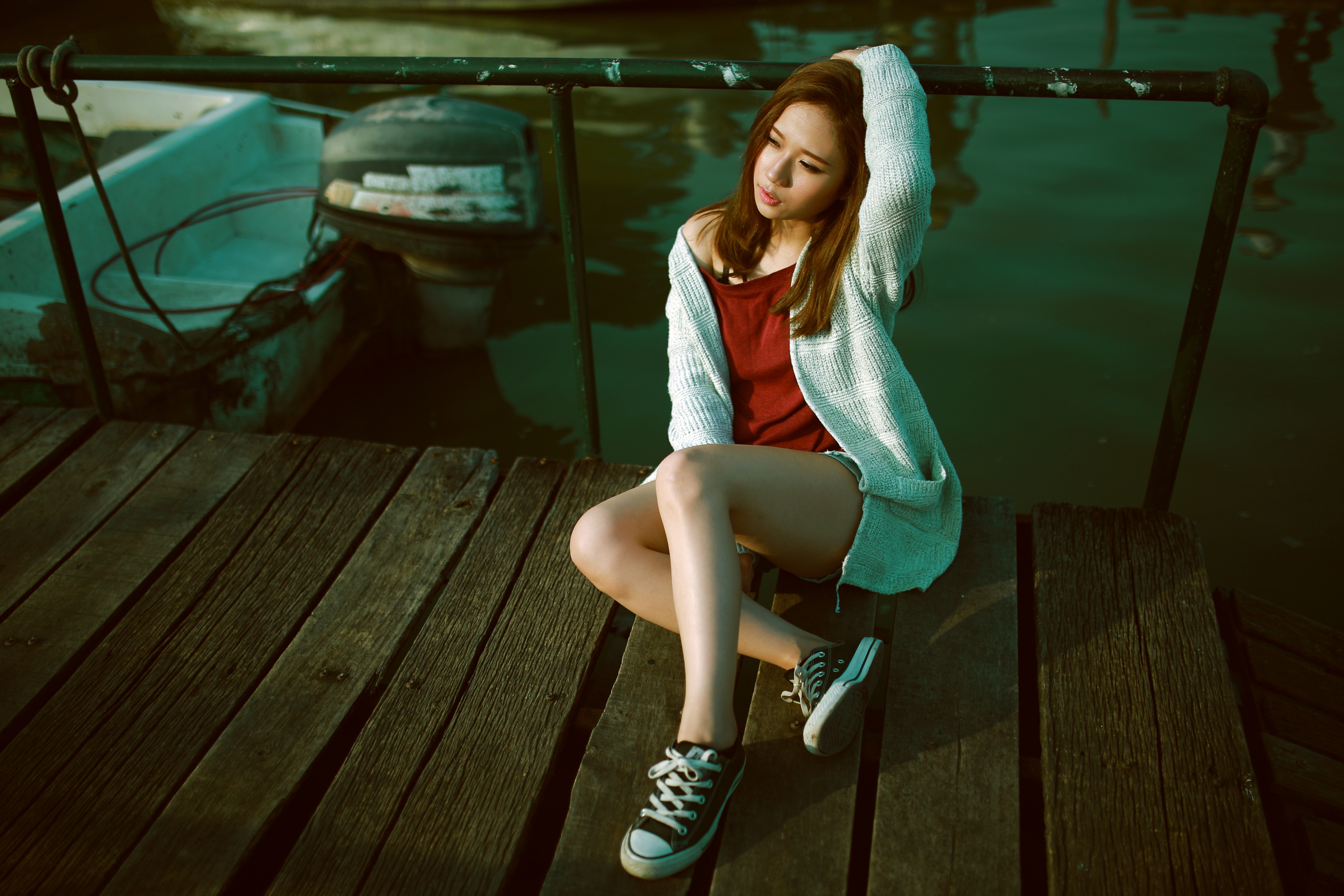 Asian woman sitting on a wooden pier next to a boat HD Wallpaper