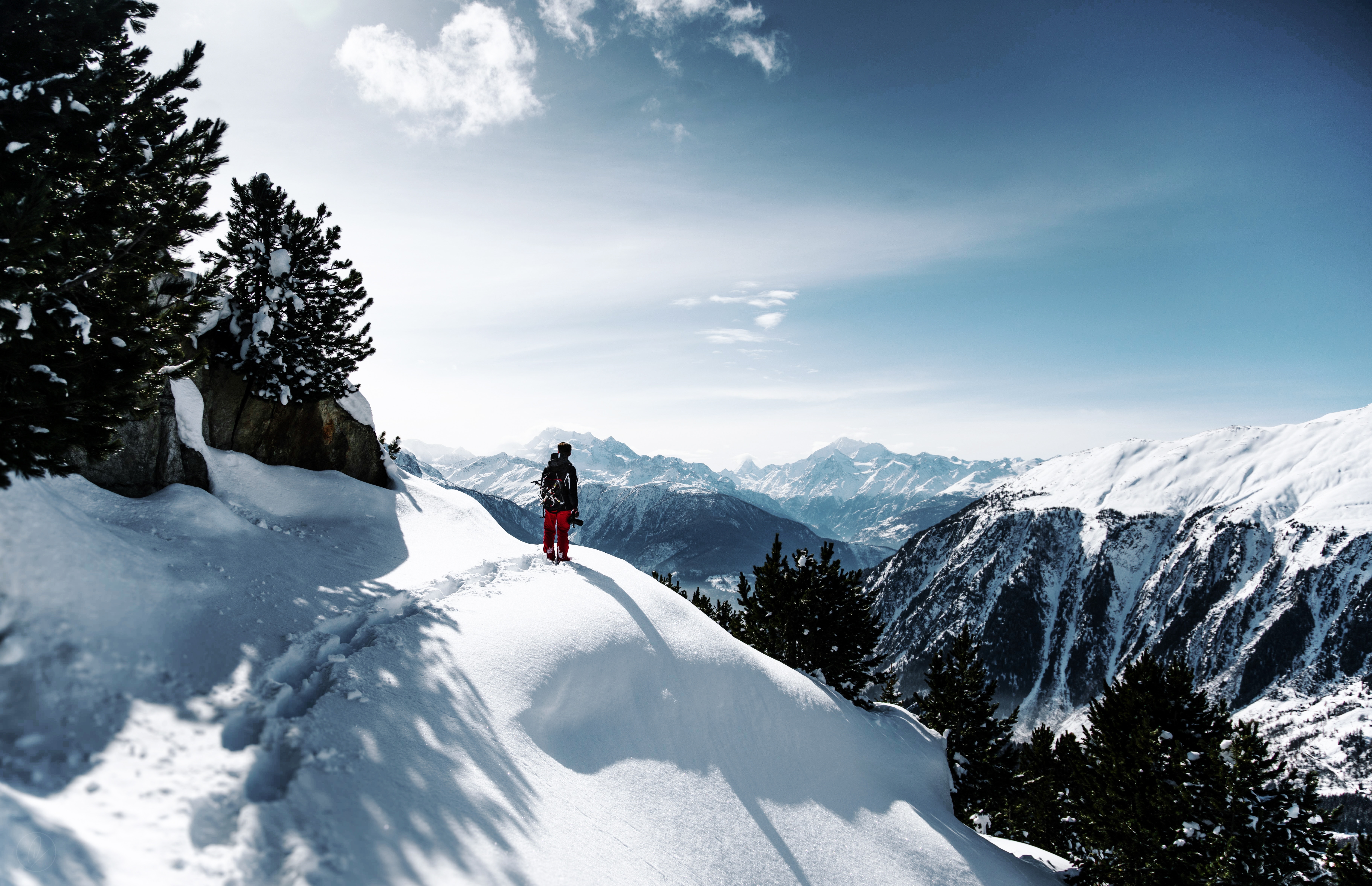 Person hiking on a snowy mountain slope HD Wallpaper