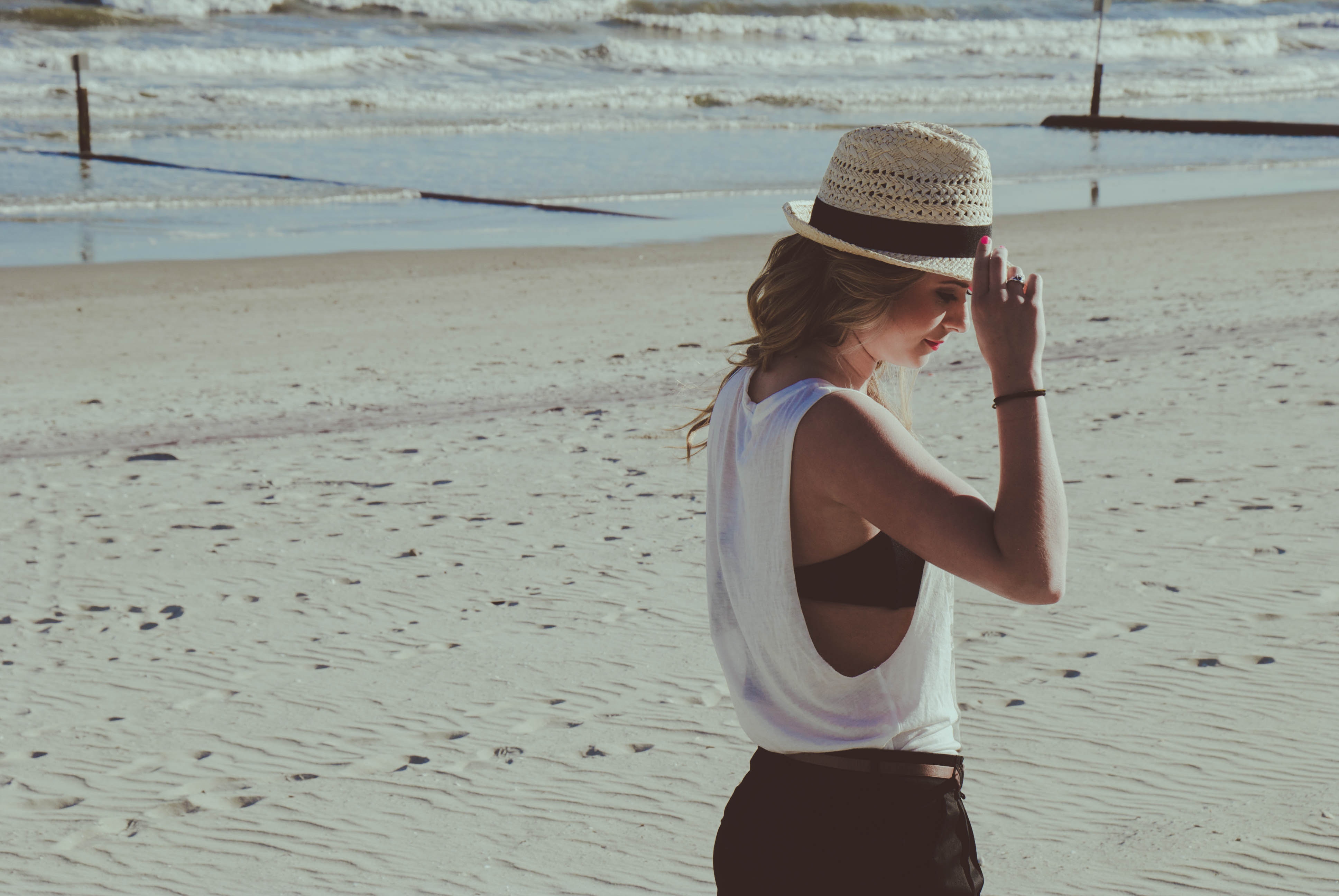 Woman in hat on a sandy beach near the sea HD Wallpaper
