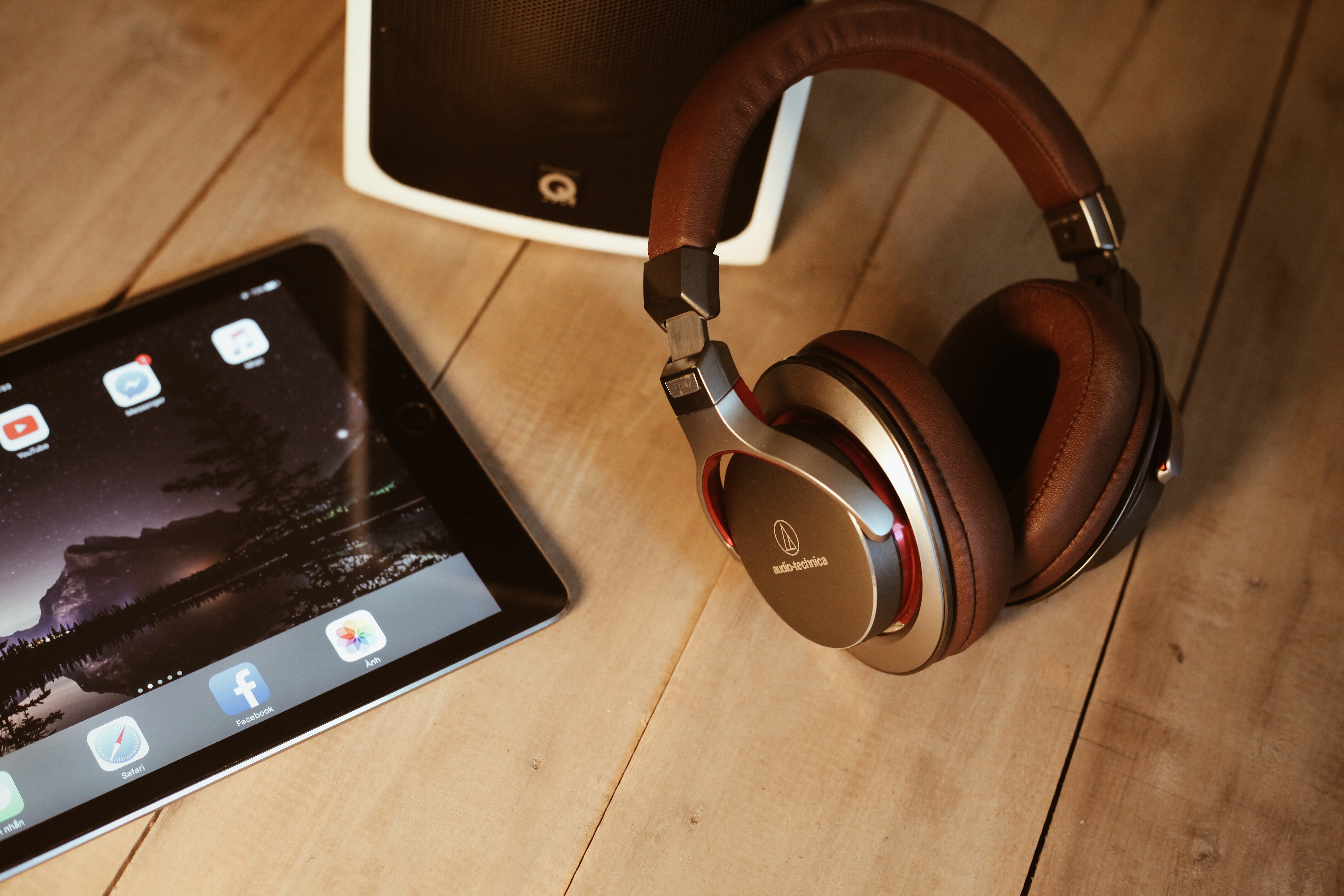 Audio-Technica headphones and tablet on a wooden desk HD Wallpaper