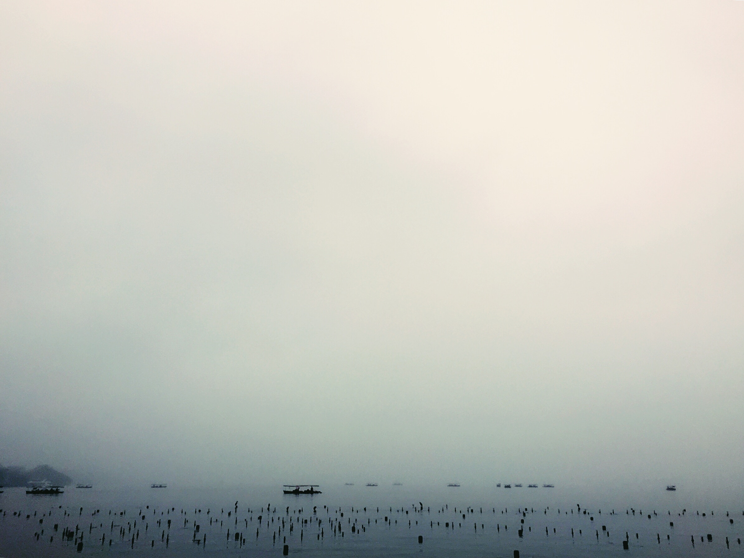 Boats and posts in a foggy sea HD Wallpaper