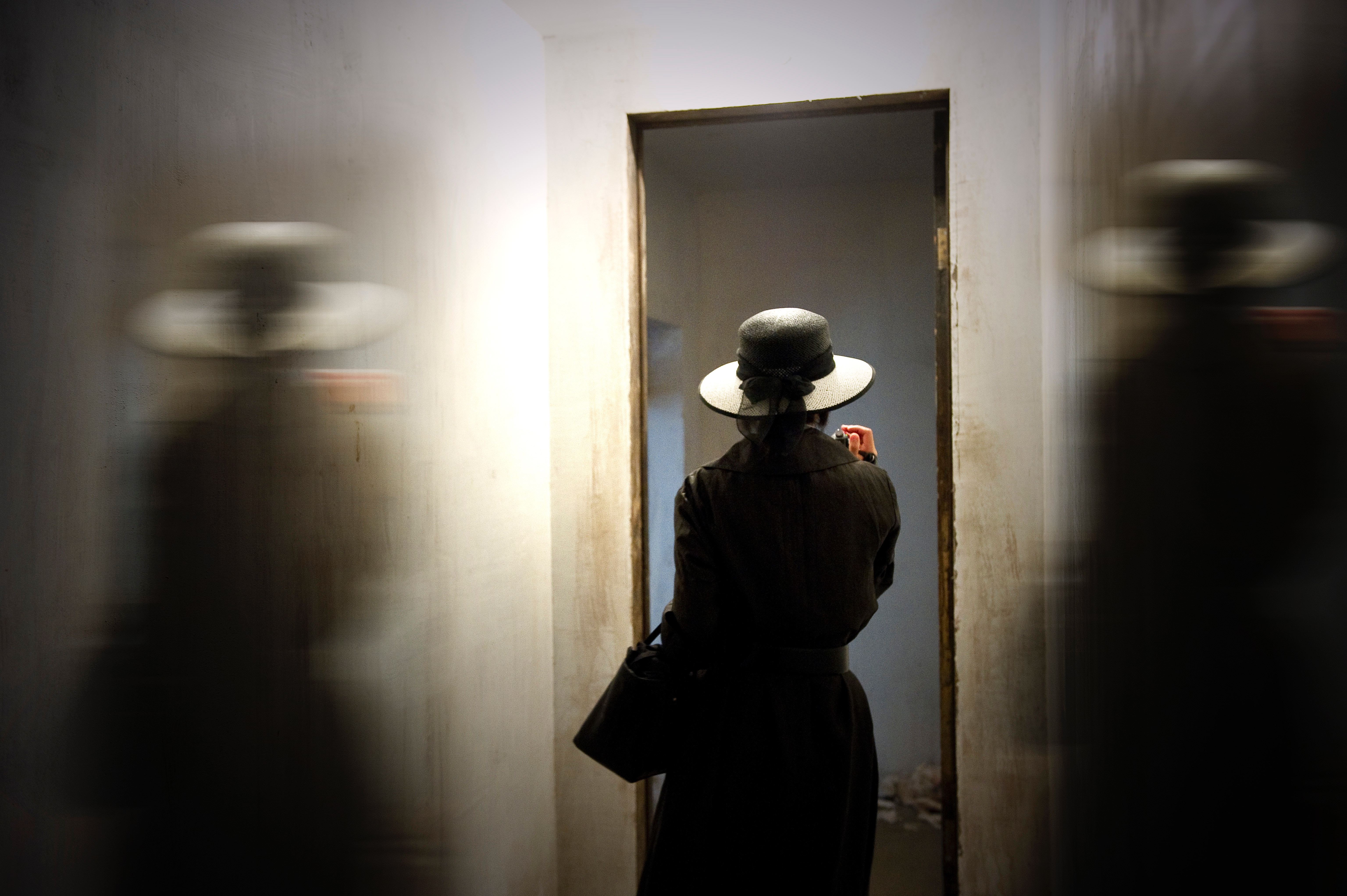 Woman in hat taking photo in doorway HD Wallpaper