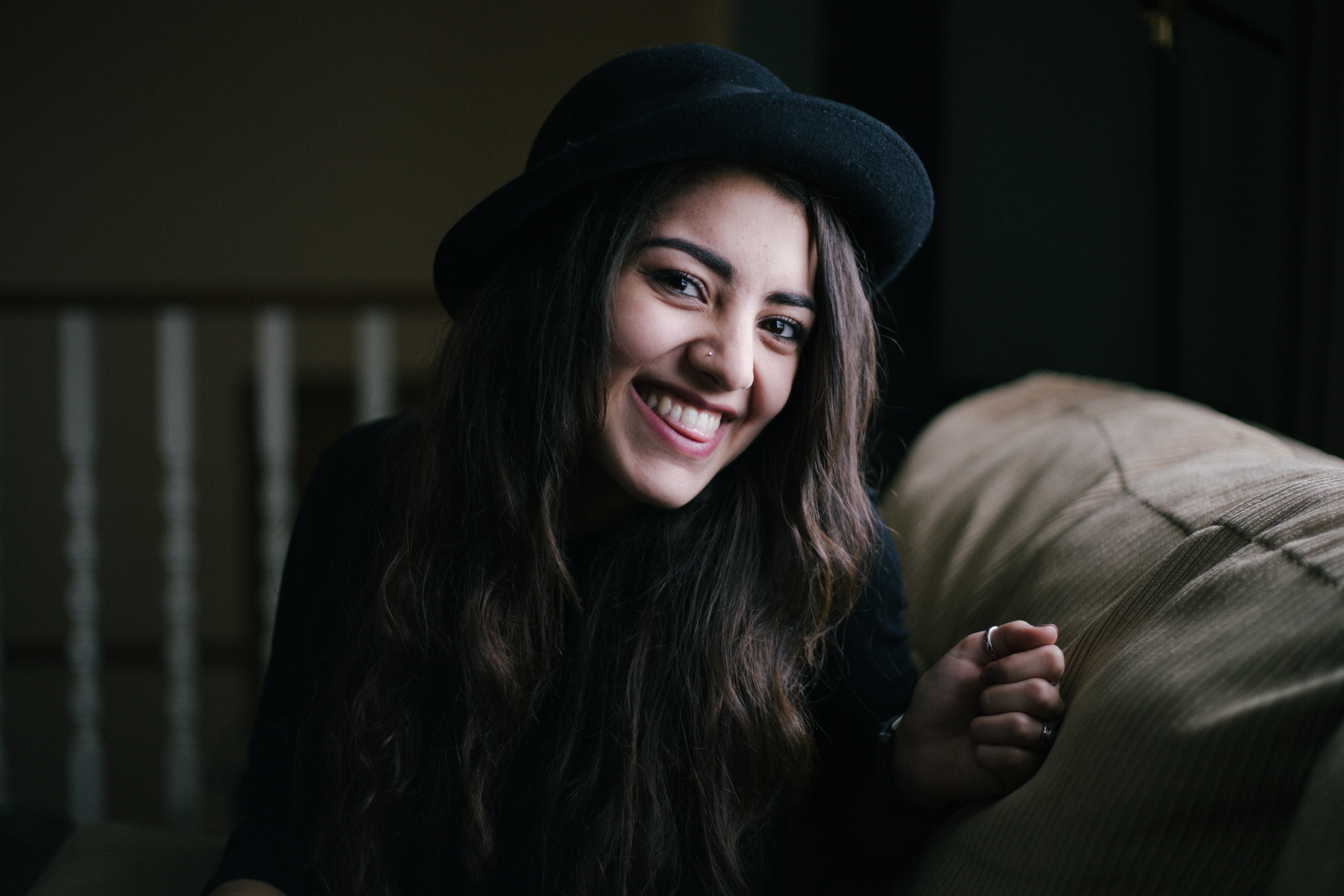 Woman wearing a black hat smiling HD Wallpaper