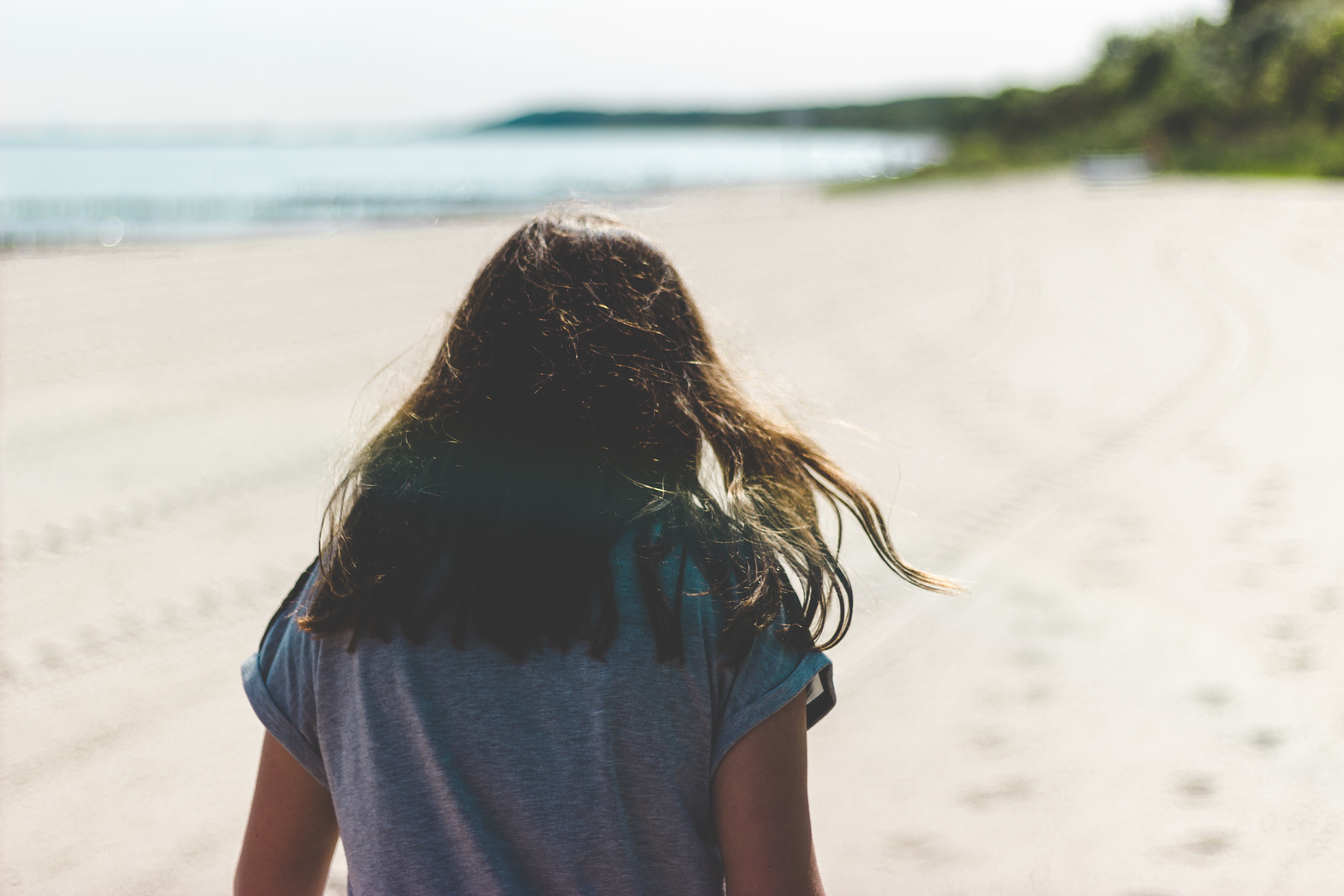 Woman walking on a sandy beach by the sea HD Wallpaper