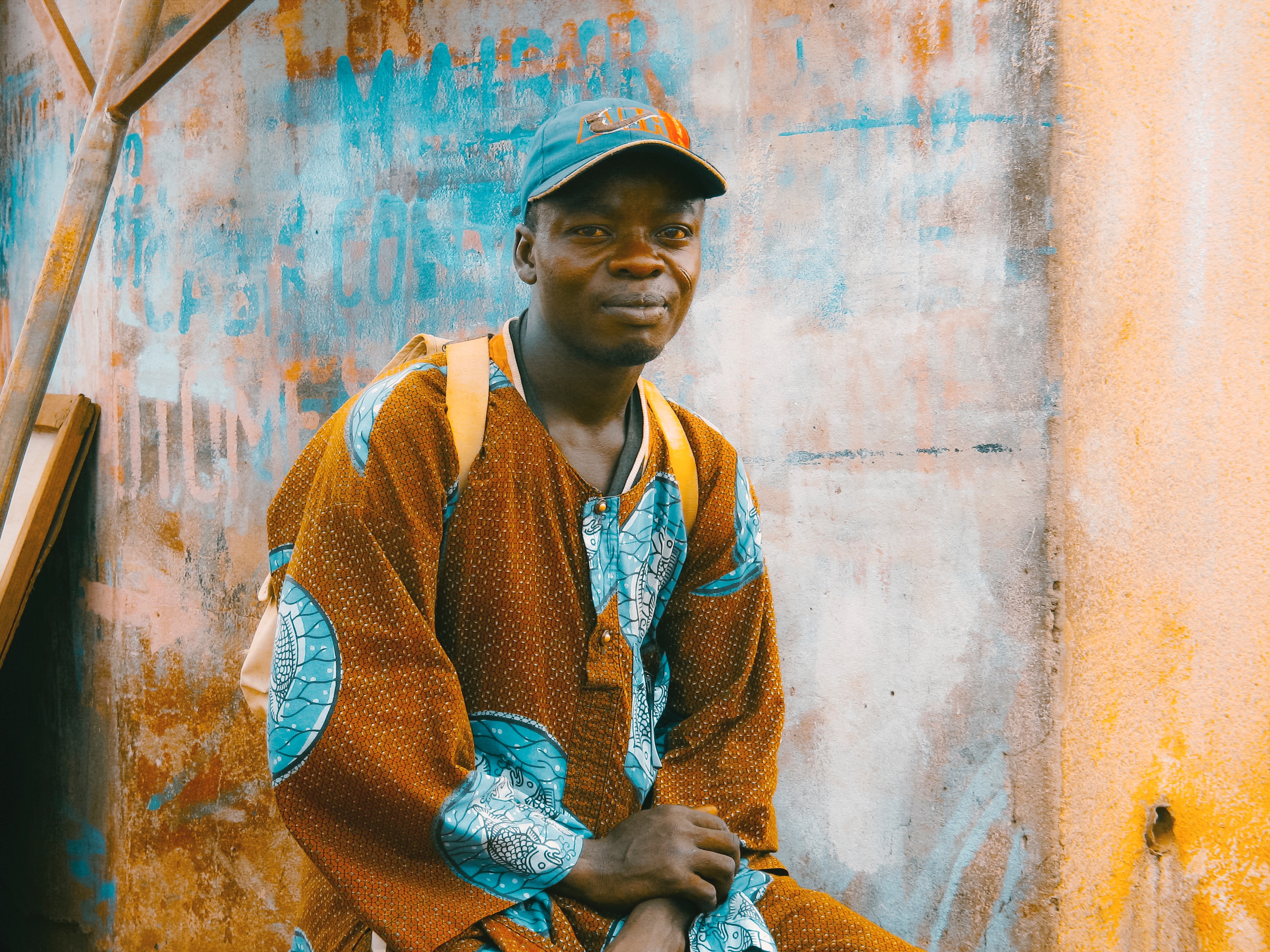 Man in colorful African clothing and cap HD Wallpaper