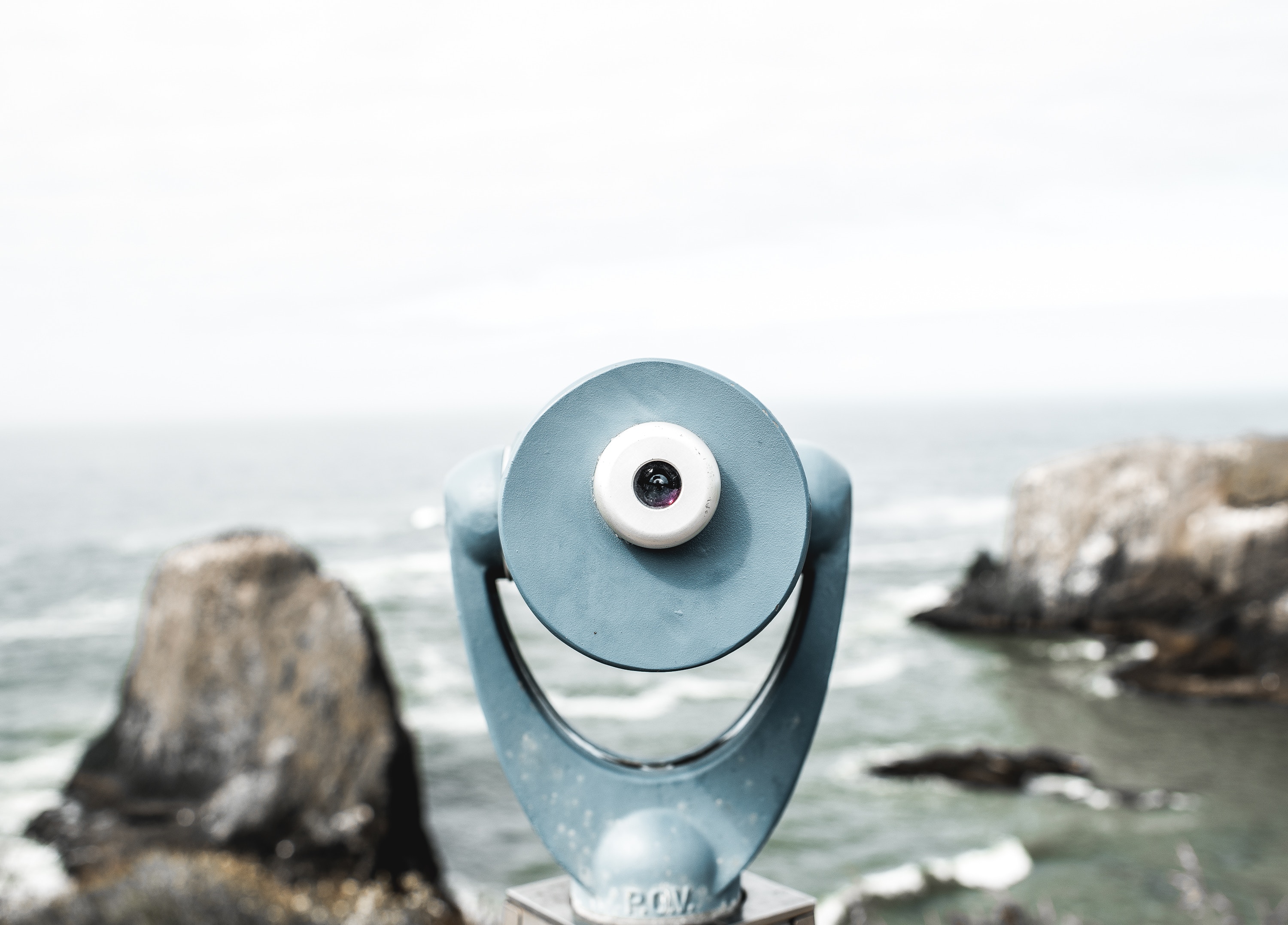 Coin-operated telescope overlooking the ocean and rocky coastline HD Wallpaper