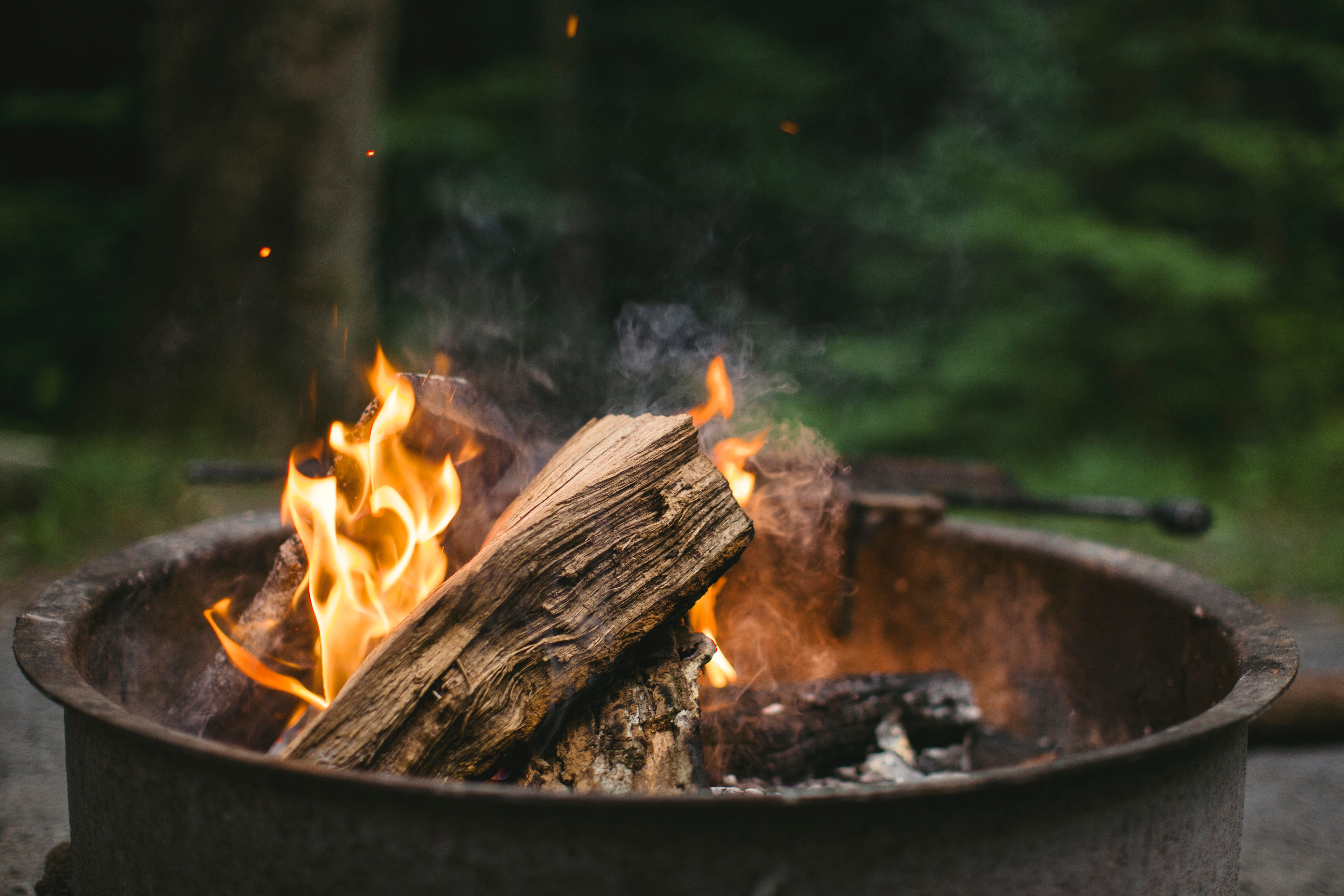 Campfire burning in a fire pit outdoors HD Wallpaper