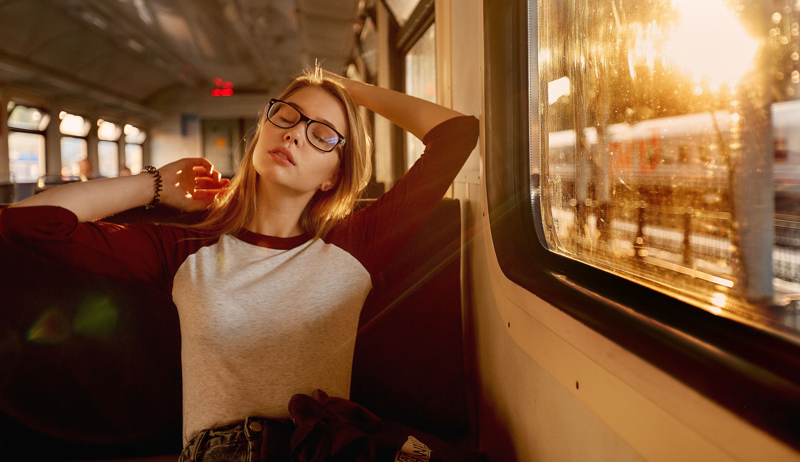 Young Woman with Glasses Relaxing on Train Outdoors HD Wallpaper