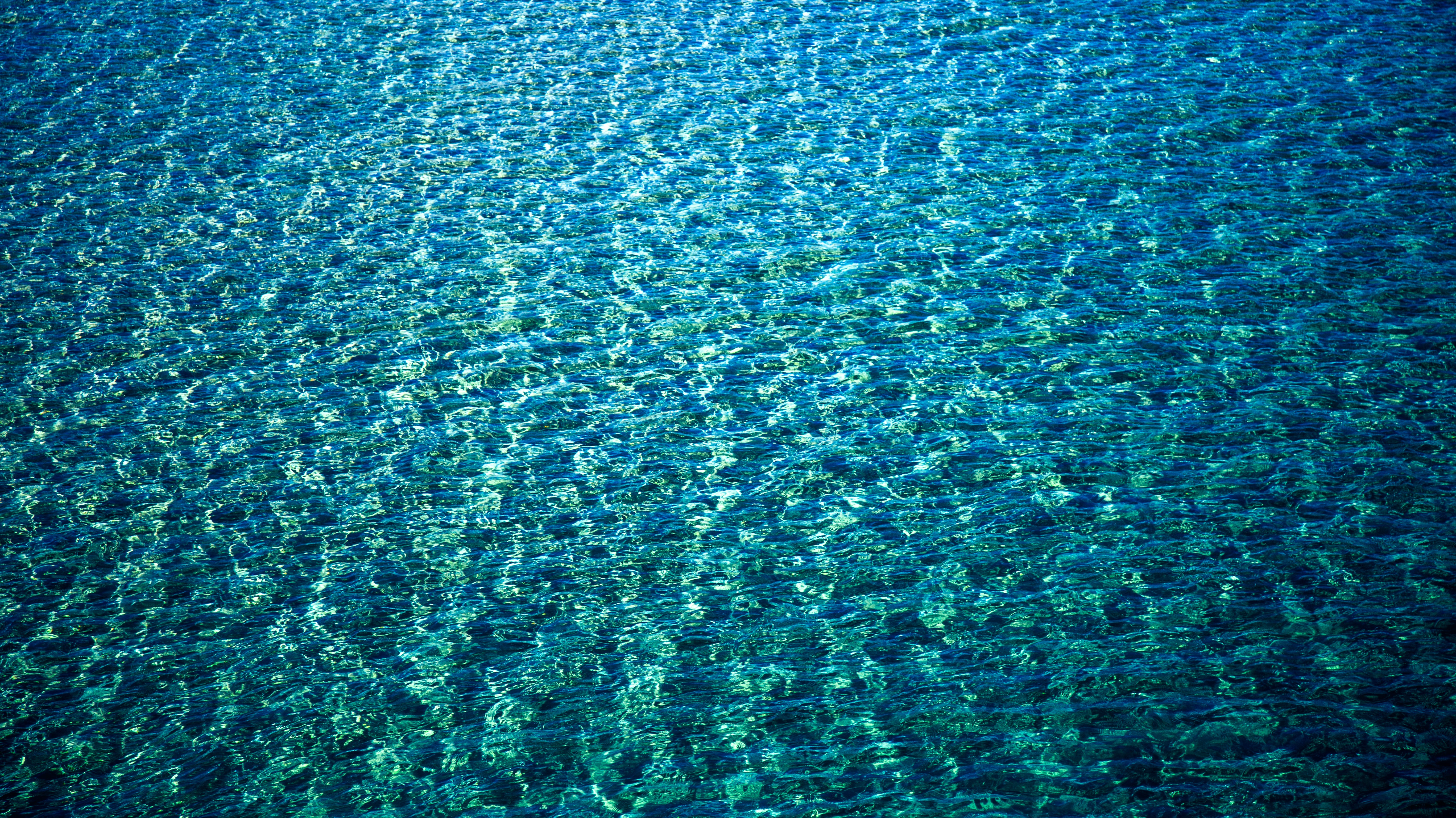 Blue ocean water with ripples and sunlight HD Wallpaper